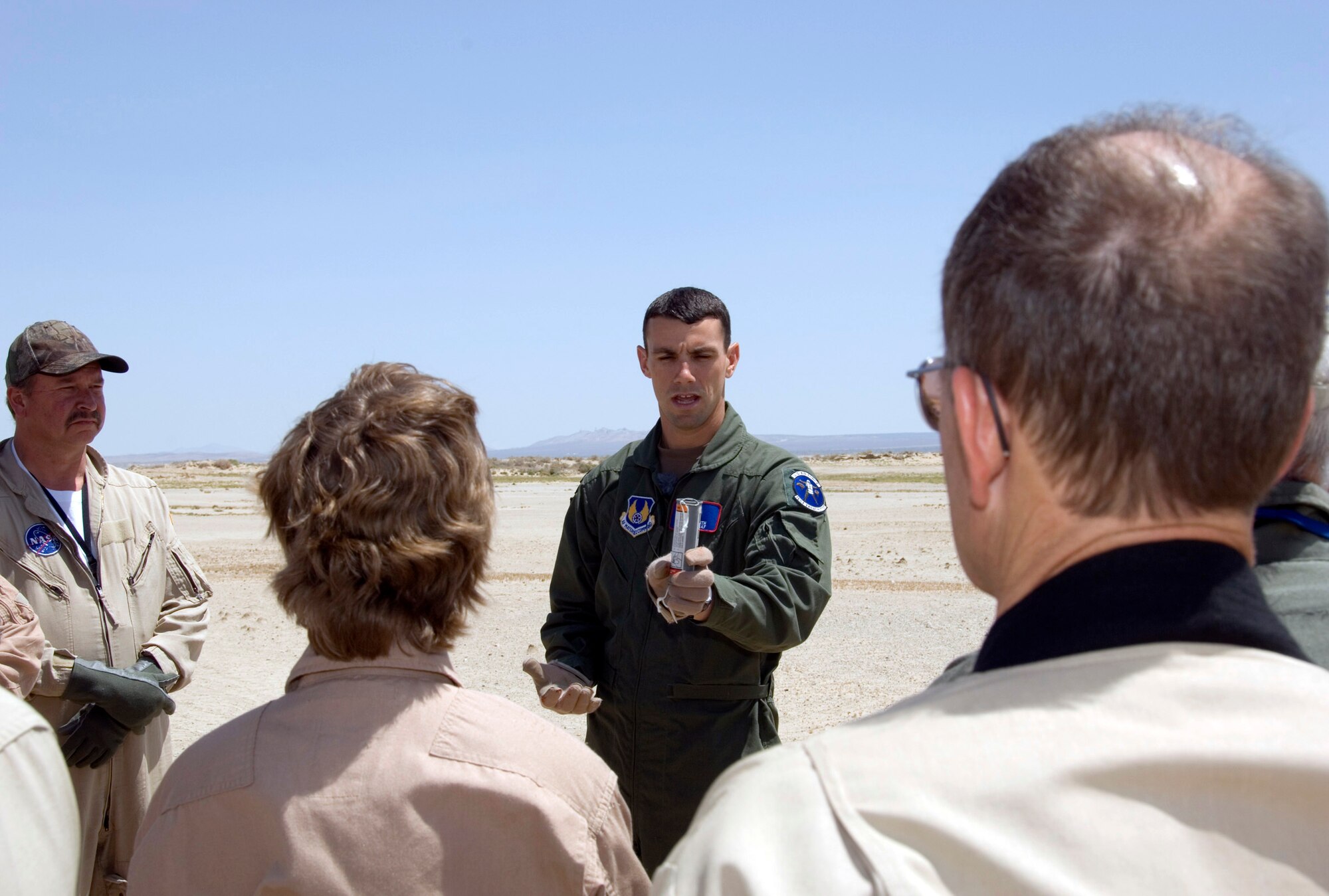 Staff Sgt. Brandon Smith (right), an Edwards survival, evasion, resistance and escape instructor, demonstrates the proper way to hold a flare during ignition as part of a land and water survival training session here May 6 and 7. Air Force and NASA Dryden Flight Research Center flight personnel received training on raft survival, psychological and physiological stress training as well as large vessel and helicopter pickups. (NASA photo by Tony Landis)