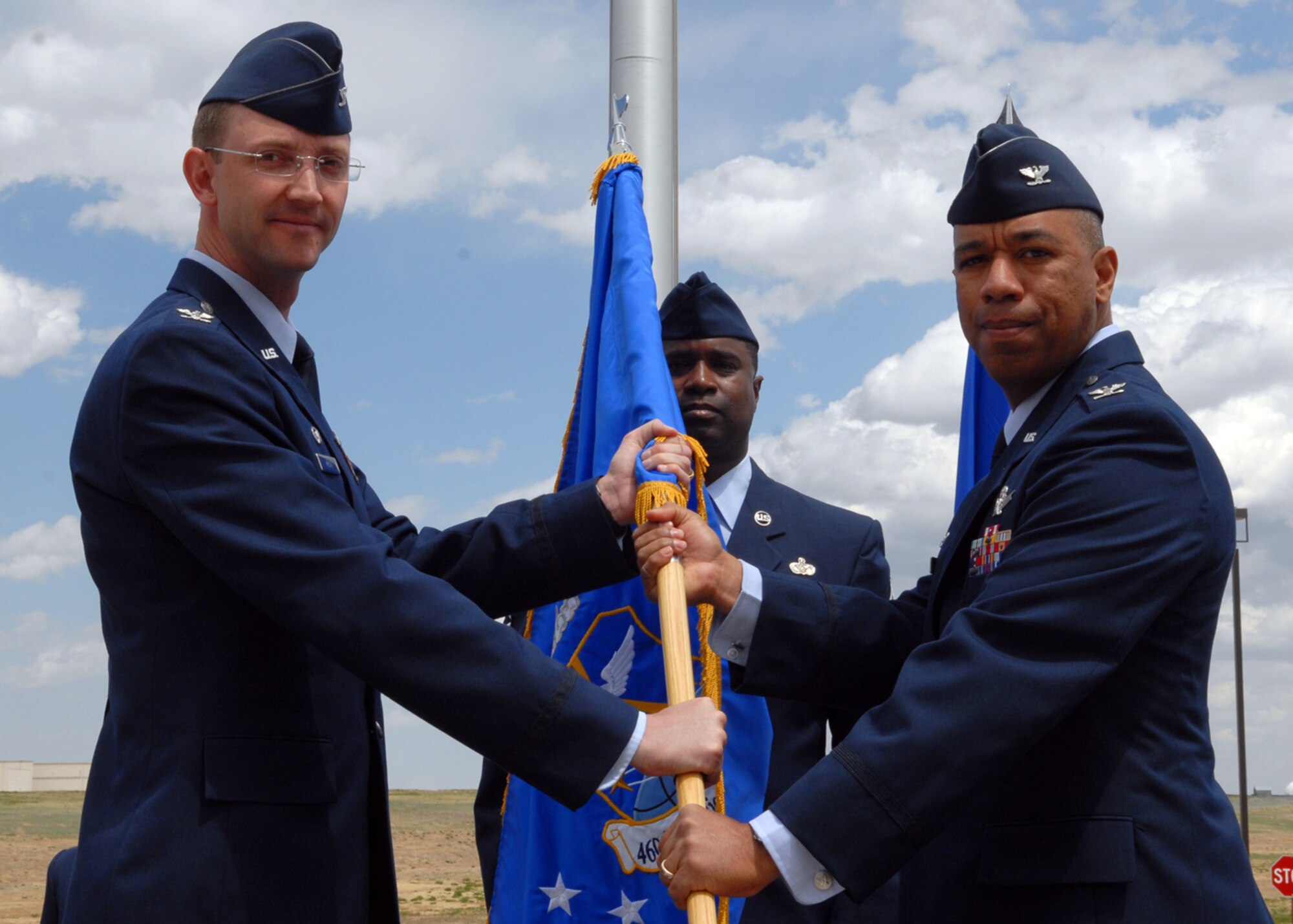 BUCKLEY AIR FORCE BASE, Colo. -- Col. Vincent Jefferson assumes command of the 460th Mission Support Group as Col. Wayne McGee, 460th Space Wing commander, presents him with the flag symbolizing the asumption of command. The ceremony took place here, May 9, in front of the Wing Headquarters Building. (U.S. Air Force photo by Senior Airman Michelle Lee Cross Furtado)