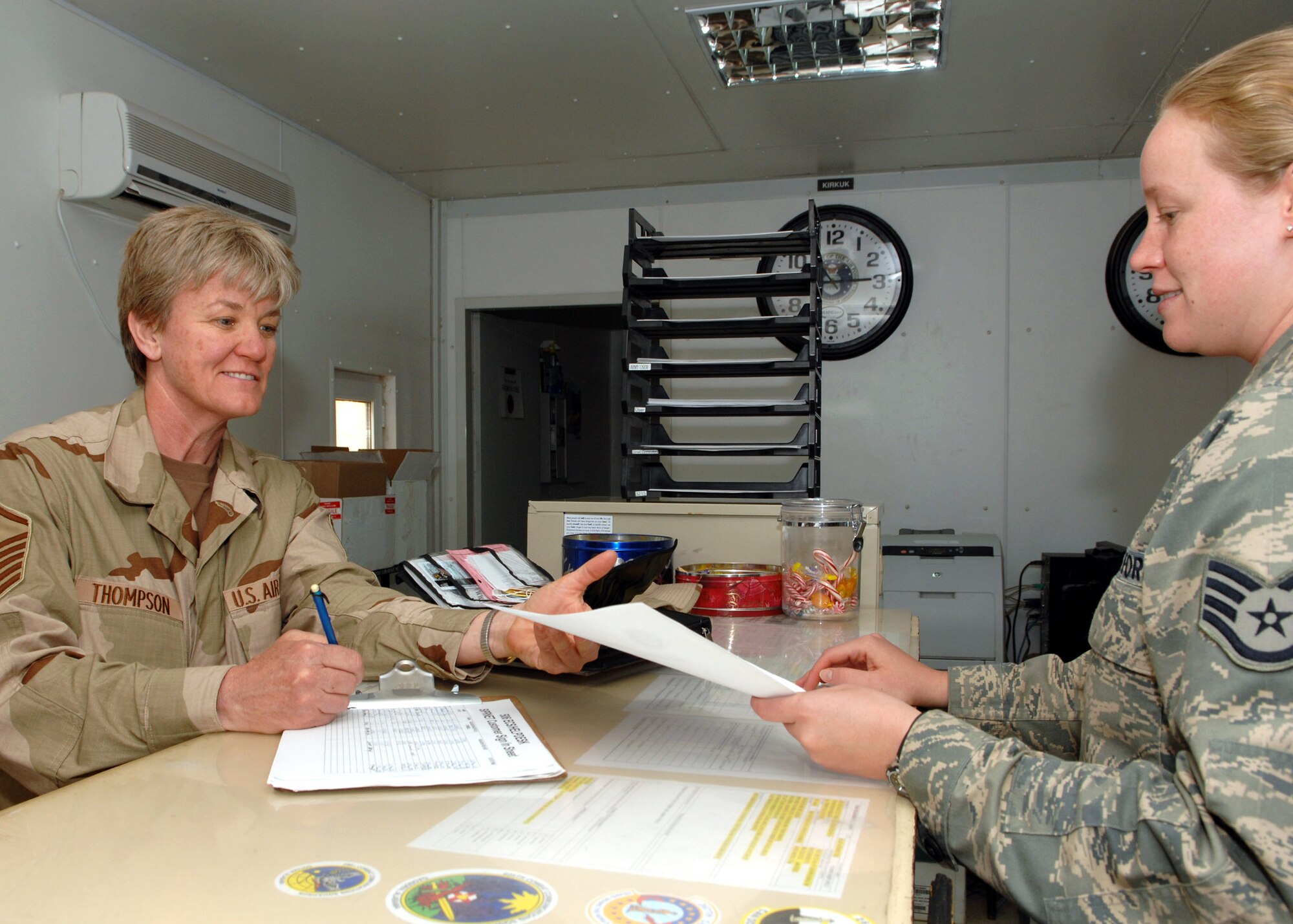 KIRKUK REGIONAL AIR BASE, Iraq – Master Sgt. Linda Thompson (right), 506th Expeditionary Civil Engineering Squadron, receives assistance from Staff Sgt. Jaclynn Gaddis, 506th Expeditionary Communications Squadron, to activate her internet service as part of an in-processing checklist May 9 here. Sergeant Thompson is a firefighter deployed here from Tinker Air Force Base, Okla., and is a native of Altus, Okla. Sergeant Gaddis is a help desk technician deployed here from Shaw AFB, S.C., and is a native of Manchester, Tenn. (U.S. Air Force photo by Senior Airman SerMae Lampkin)