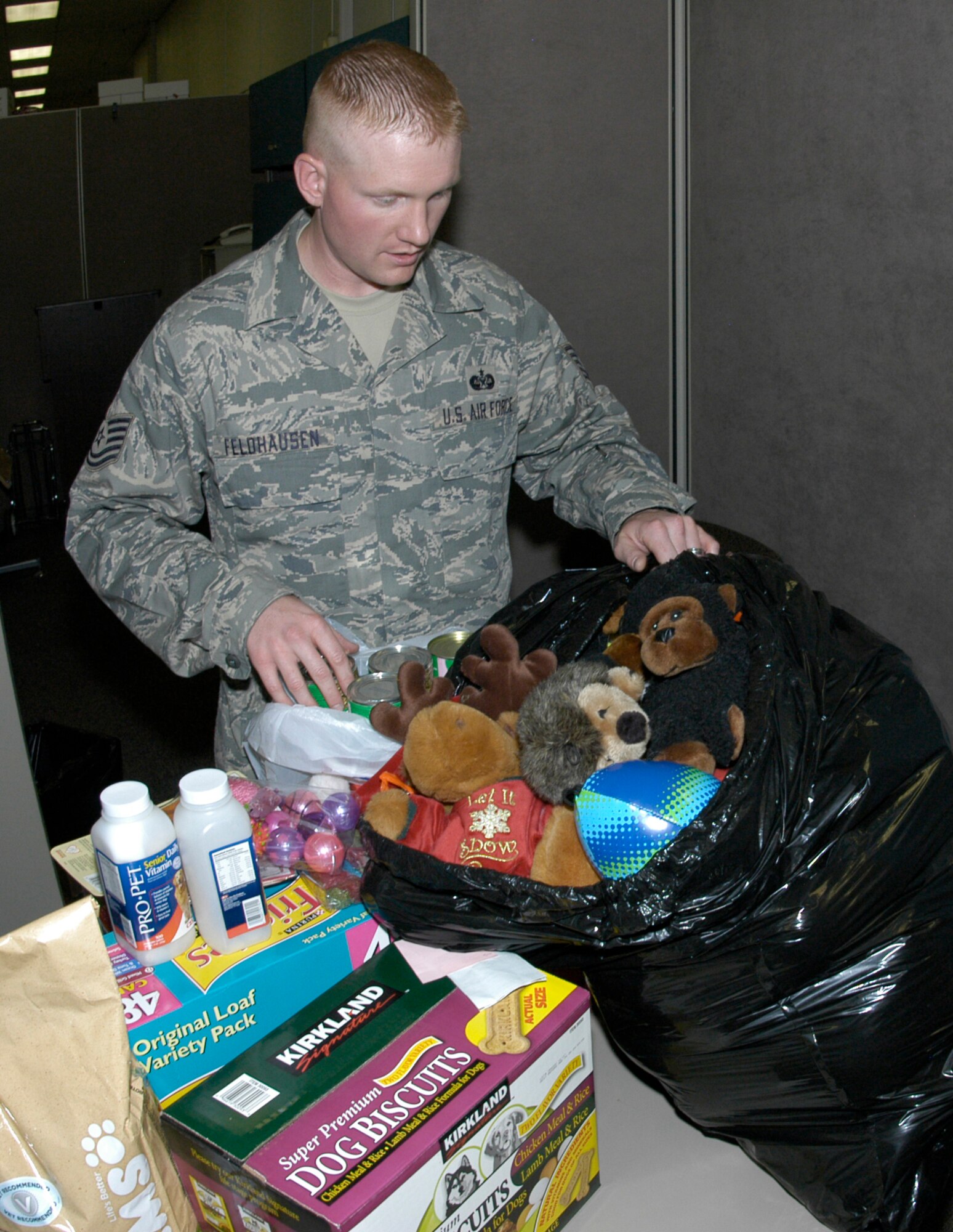 Tech. Sgt. Lee Feldhausen, JA, sorts pet food and supply donations collected at the Air Reserve Personnel Center on May 9. Sergeant Feldhausen and Staff Sgt. Sean Byerly, SC, are leading the Junior Enlisted Advisory Council's pet food and supply drive through May 16. The annual drive at ARPC collects donations for Denver's MaxFund no-kill animal shelter. (U.S. Air Force photo/Mike Molina)                                 