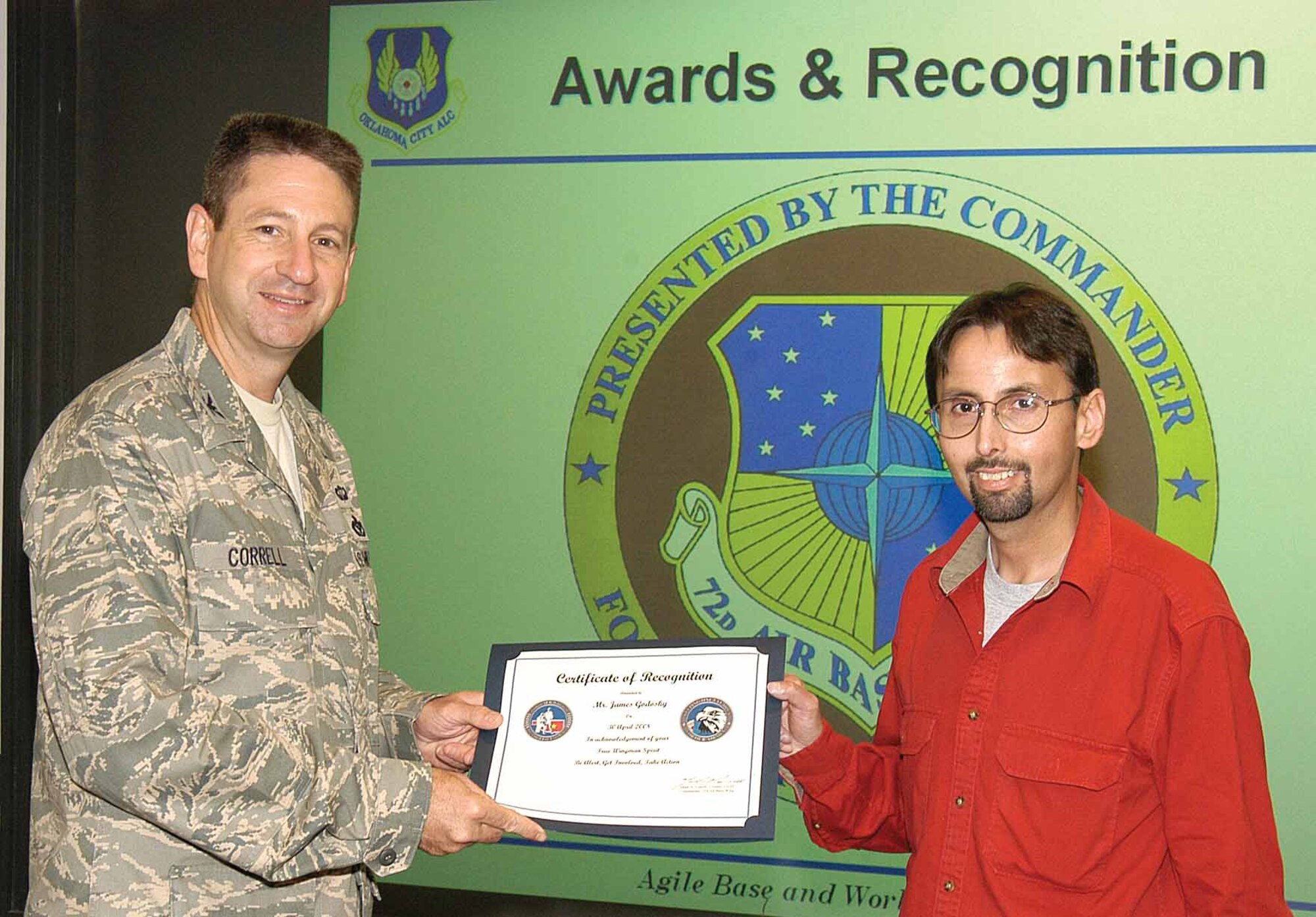James Godosky is thanked by 72nd Air Base Wing and Tinker Installation Commander, Col. Mark Correll, for extinguishing a fire outside Bldg. 460 recently.  Mr. Godosky, a Dale Rogers employee who maintains the building, grabbed a fire extinguisher and put out the growing fire when he saw it in the mulch near the headquarters building.  The commander presented him with a Wingman coin and appreciation certificate before a wing staff meeting May 7.  (Air Force photo by Margo Wright) 
