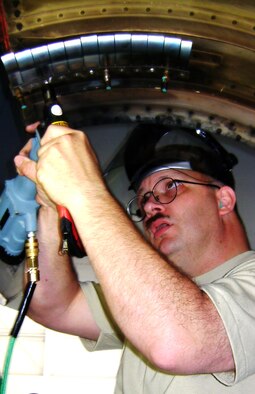 ANDREWS AIR FORCE BASE, Md. -- Tech Sgt. Barry Gilbert, 459th Maintenance Squadron, structural repair mechanic craftsman, installs an F-108 engine crowl door finger seal located on a nacelle panel of a KC-135 aircraft. (U.S. Air Force photo/Senior Airman Ashley Crawford)