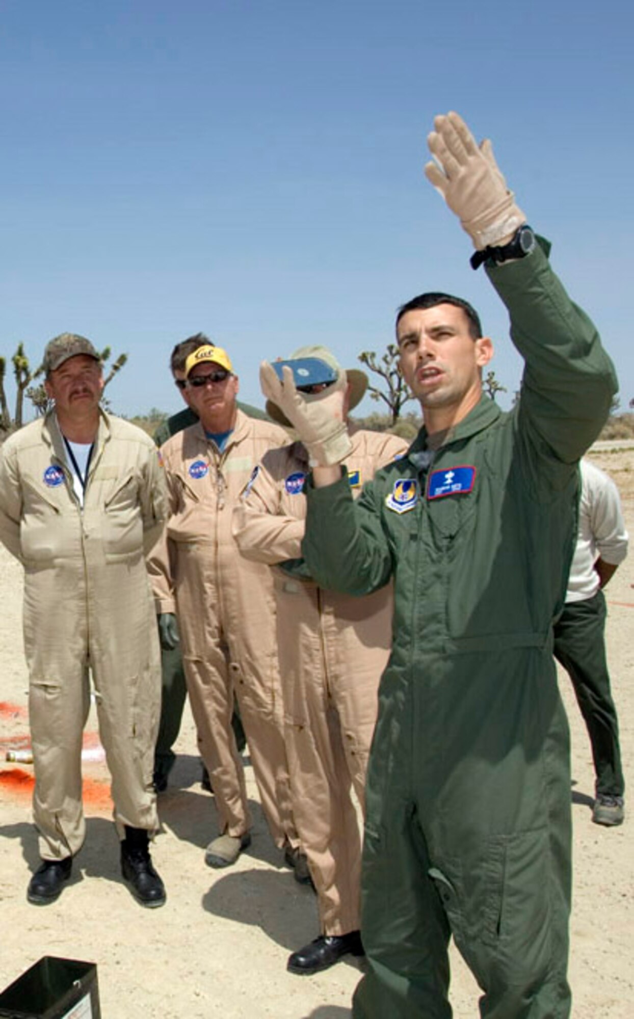 Staff Sgt. Brandon Smith (right), an Edwards survival, evasion, resistance and escape instructor, demonstrates the proper technique when using a signaling mirror during a joint land and water survival training session here May 6 and 7. The NASA and Air Force students received training on raft survival, psychological and physiological stress training as well as large vessel and helicopter pickups. (NASA photo by Tony Landis)