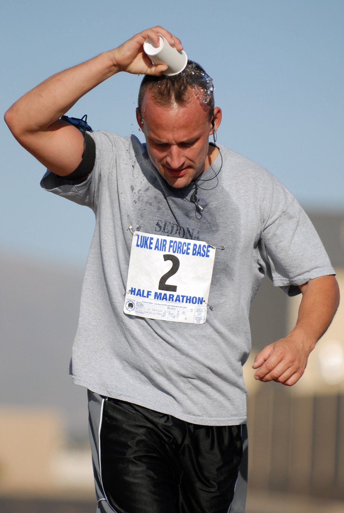 Tech. Sgt. Mark Aube cools off with a cup of water during the half marathon May 3 at Luke Air Force Base, Ariz. Fifty-four runners logged more than 700 miles during the run. Sergeant Aube is an electrical environmental technician with the 309th Aircraft Maintenance Unit. (U.S. Air Force photo/Staff Sgt. Jerry Fleshman)