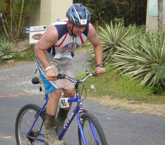 Air Force Capt. Manny Silveira, a Joint Task Force-Bravo participant in the Bay Islands Triathlon, climbs a hill during the bike portion of the competition May 5. Twenty-eight JTF-Bravo personnel competed in the event with all completing the race.