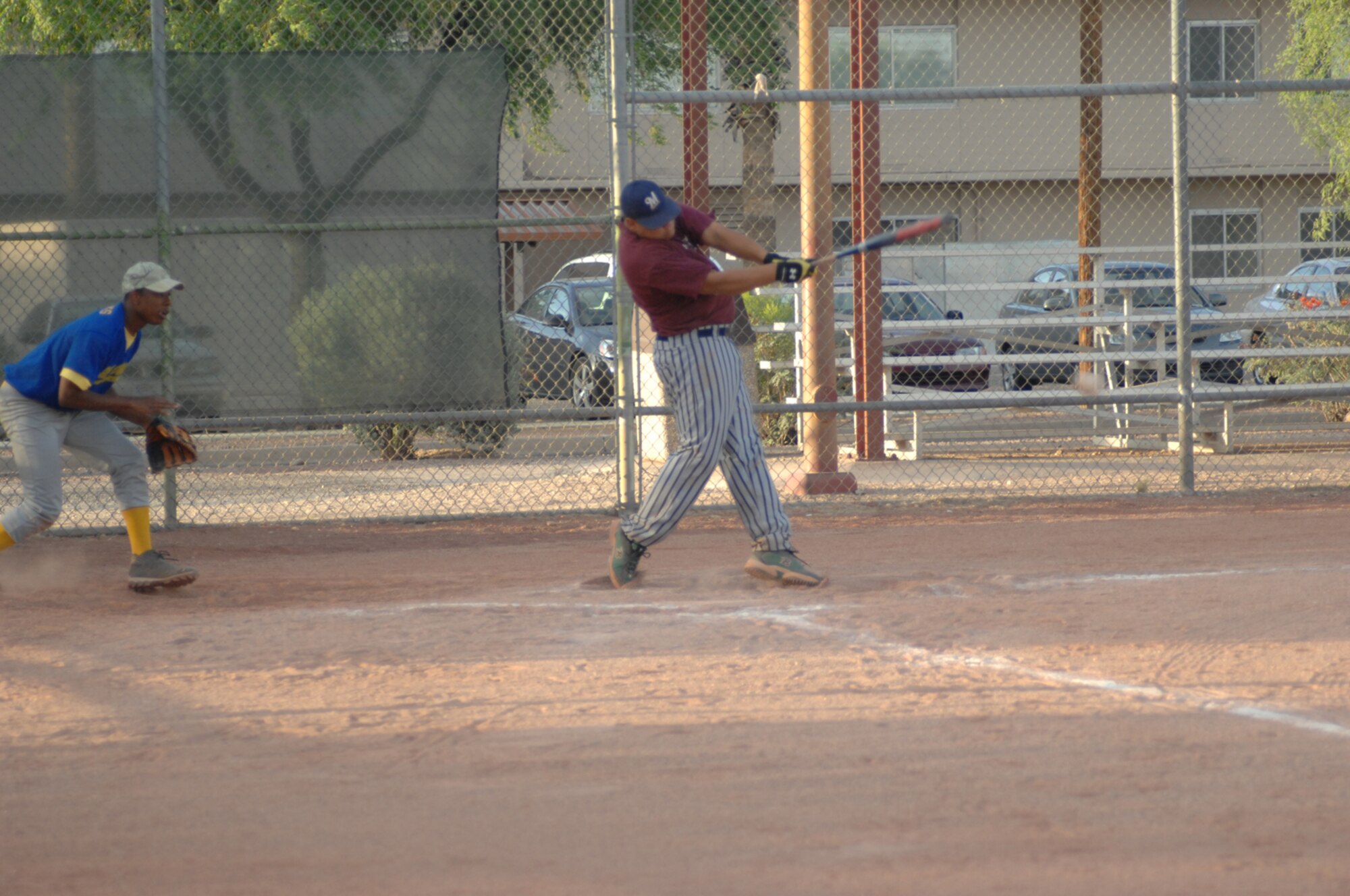 A member Med Groupgets a hit off a member of OWS in a 33-10 Med Group victory of a D-M intramural softball leage game May 8. (U.S. Air Force photo by Senior Airman Alesia Goosic)
