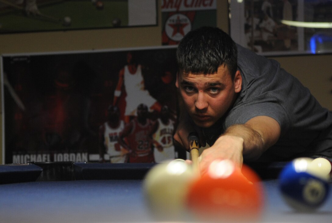 Airman Chris Harris, 28th Civil Engineer Squadron heating, ventilation, air conditioning and refrigeration apprentice, takes a long shot and pockets the five ball during the first Airmen Billiard Tournament, May 7.  The tournament began May 7 and will run through June 25; finals begin June 28. (U.S. Air Force photo/Senior Airman Anthony Sanchelli)