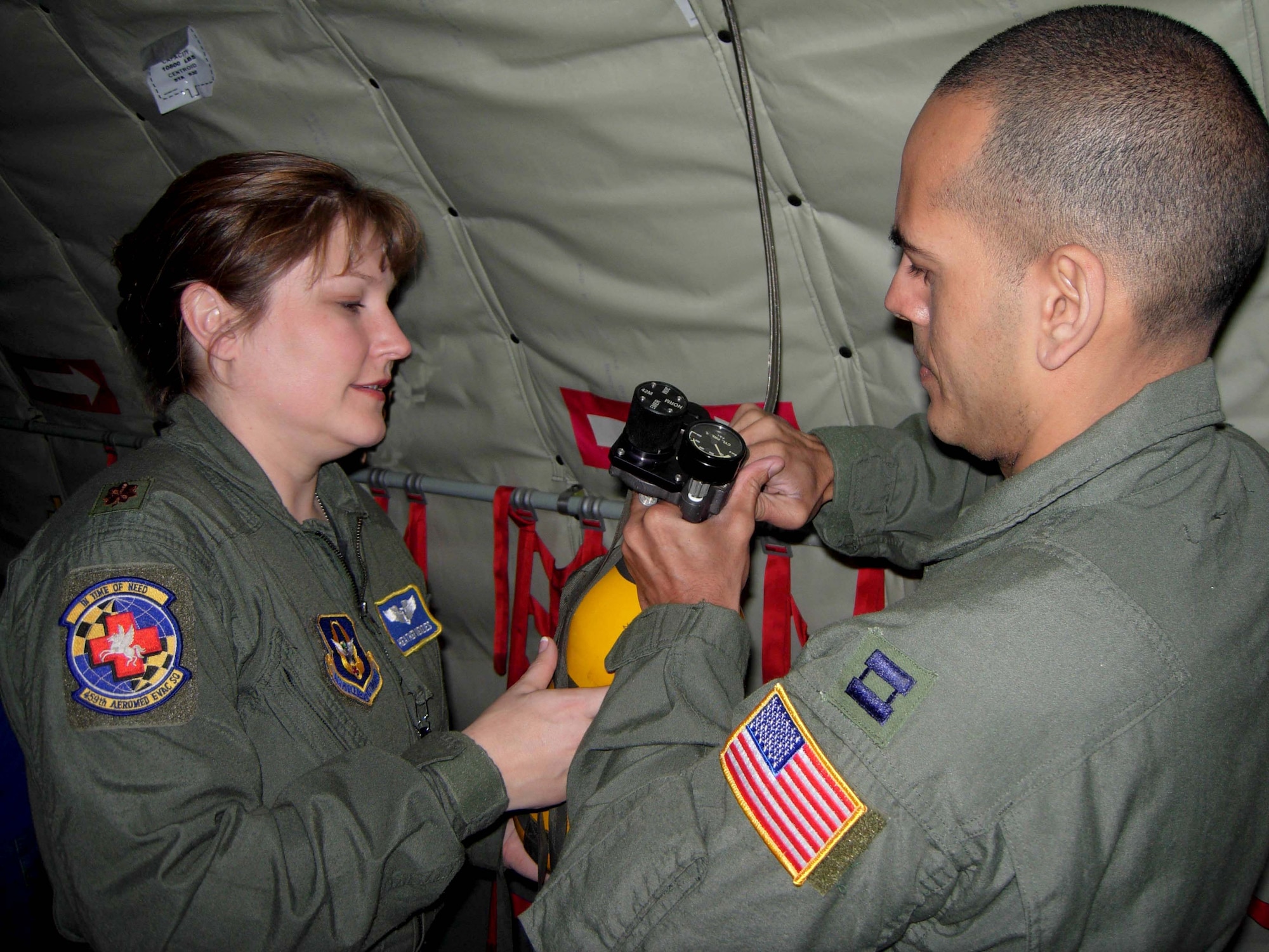 ST. CROIX, U.S.VIRGIN ISLANDS -- Maj. Heather Menzies and Capt. Eliud Lamboy, 459th Aeromedical Evacuation Squadron nurses, check the pressure of an oxygen tank during an in-flight exercise. Ten members of the 439th AES joined more than a dozen 459th AES members in a blended AE training mission to the island. Mission training expanded beyond the medical realm to include air refueling and an overseas sortie. (U.S. Air Force photo/Staff Sgt. Amaani Lyle)
