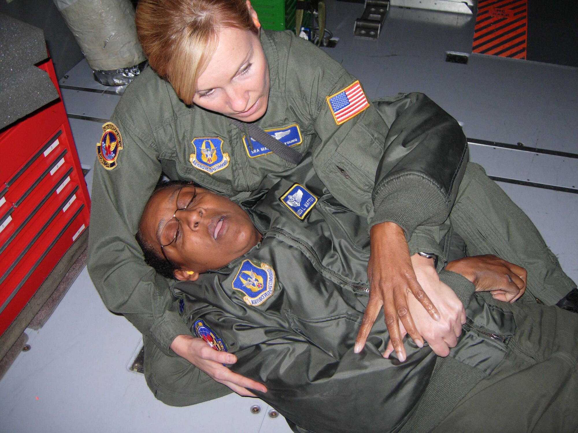 ST. CROIX, U.S.VIRGIN ISLANDS -- Senior Airman Mary Elizabeth Young, 439th Aeromedical Evacuation Squadron medical technician, subdues simulated patient Lt. Col. Vanessa Mattox, 459th Aeromedical Evacuation Squadron commander, during an in-flight exercise. Ten members of the 439th AES joined 459th AES members in a blended AE training mission to the island. Mission training expanded beyond the medical realm to include air refueling and an overseas sortie. (U.S. Air Force photo/Staff Sgt. Amaani Lyle)