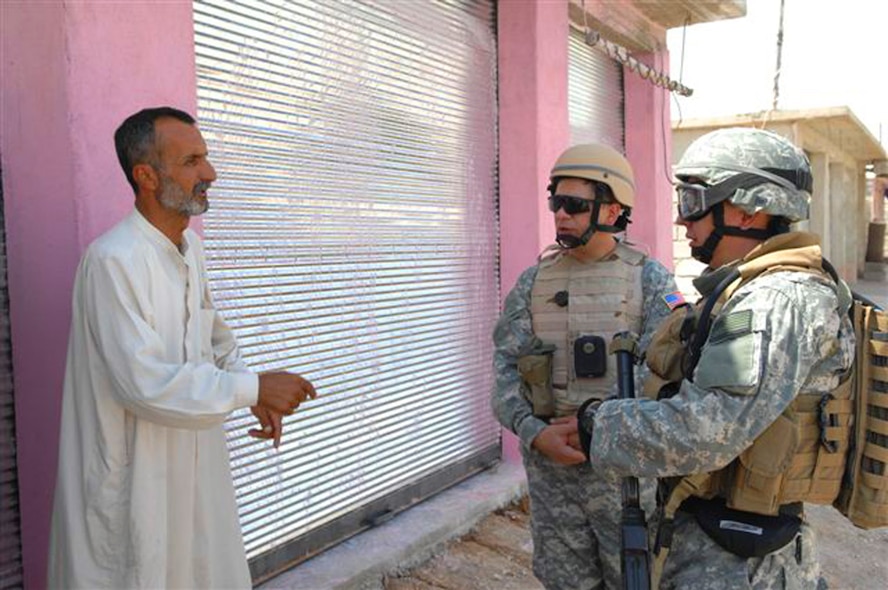 U.S. Air Force Special Agent "Michael" from the Air Force Office of Special Investigations, talks to a local shop owner with the assistance of an interpreter in a village near Kirkuk, Iraq. (U.S. Air Force photo/Staff Sgt. Dallas Edwards)