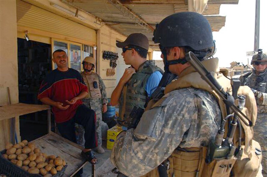 U.S. Air Force Special Agent "Phil" from the Air Force Office of Special Investigations, talks to a local market owner with the assistance of an interpreter, in a village near Kirkuk, Iraq. (U.S. Air Force photo/Staff Sgt. Dallas Edwards)