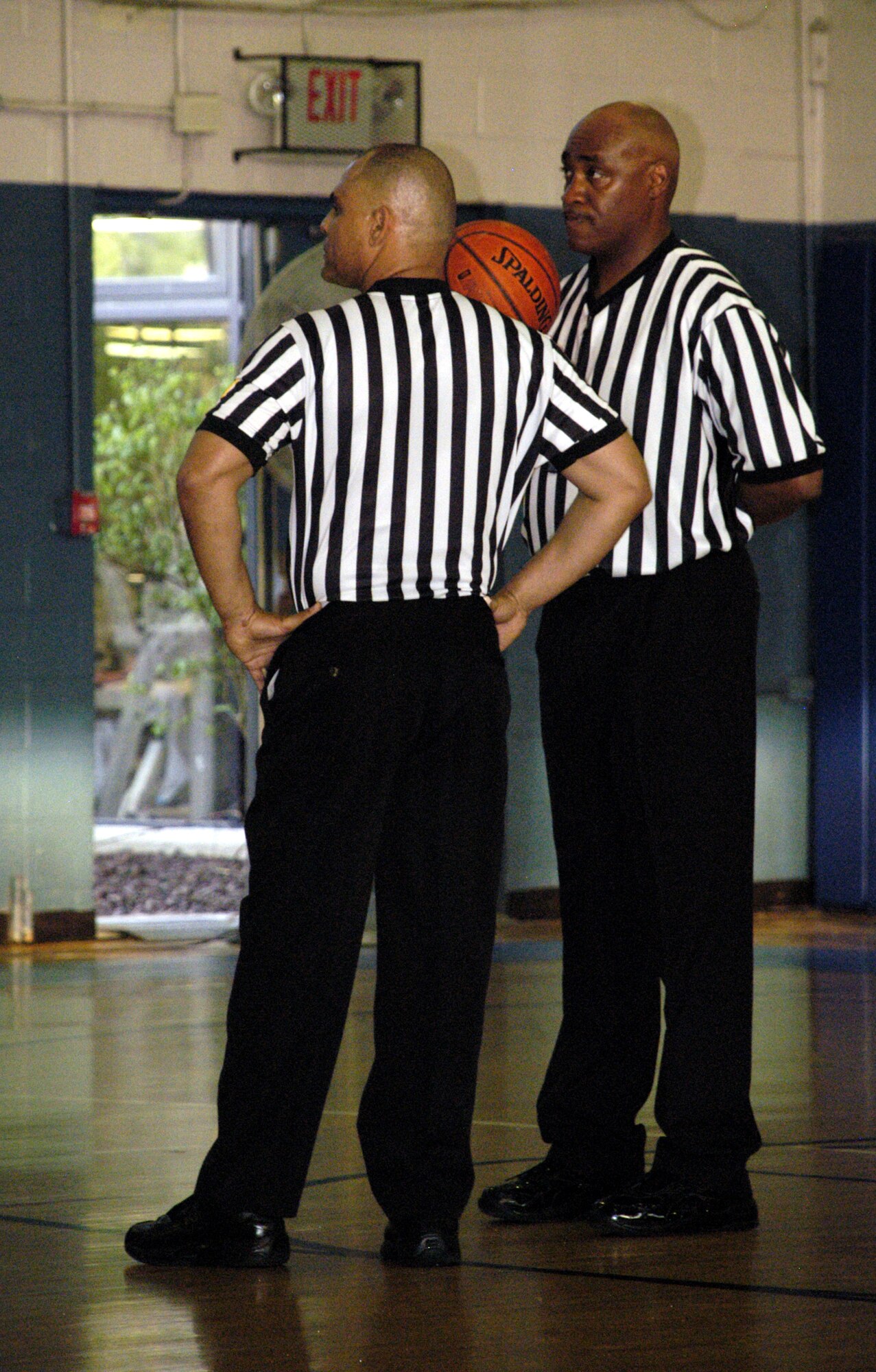 Referees Cal Williams and Raymond Hicks watch both teams as they huddle during a time-out.  (U.S. Air Force photos/Airman 1st Class Shen-Chia Chu)