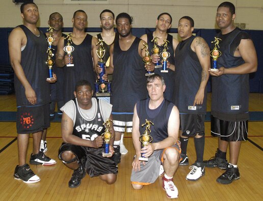 Hakim Tutt, 512th Mission Support Squadron coach, holds the championship trophy with his team after winning the intramural basketball championship at the Fitness Center May 4. The 512th MSS beat 436th MXS 39 – 38 in the final game. (U.S. Air Force photos/Airman 1st Class Shen-Chia Chu)