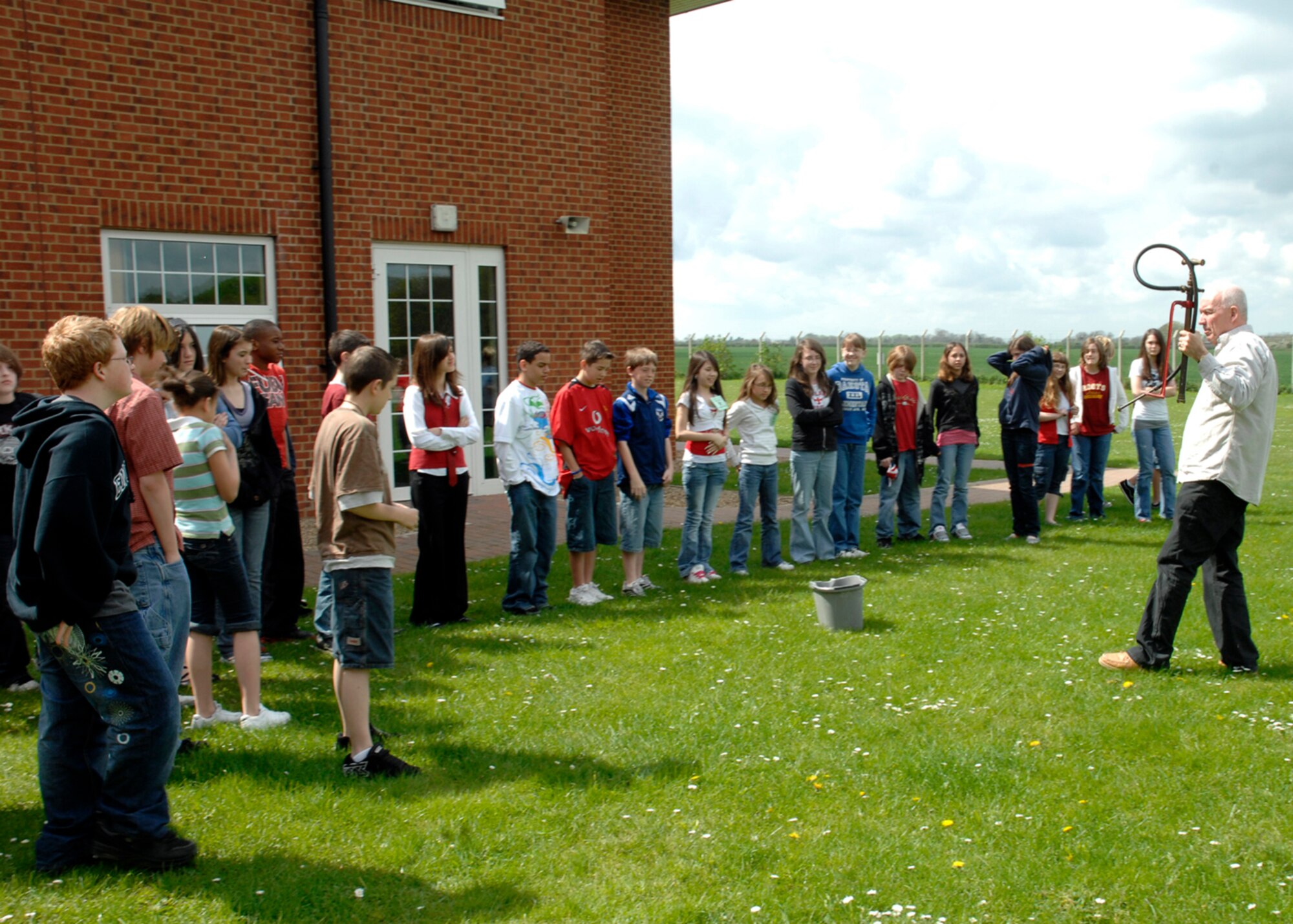 John Barwell from the Thetford Museum brought artifacts and explains the use of a stirrup pump from the World War II era May 2 on RAF Feltwell. More than 100 residents of the local community participated in the event to educate children on UK customs, history and heritage and to foster a relationship with the host nation. (U.S. Air Force photo by Airman 1st Class John Easterling)