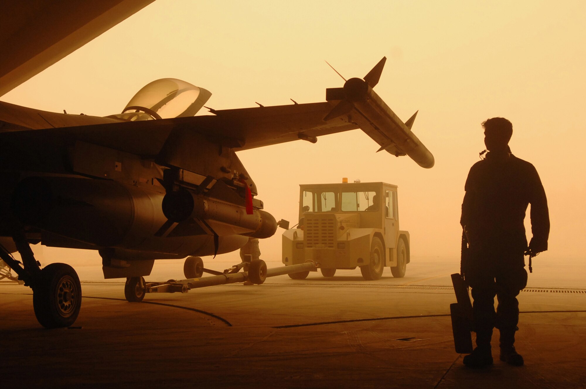 BALAD AIR BASE, Iraq -- Crew chiefs assigned to the 332nd Expeditionary Aircraft Maintenance Squadron spot an F-16 Fighting Falcon while being pushed into a hardened aircraft shelter during a major dust storm here, May 9. Protecting flightline assets from dust damage or destruction is important to maintaining the air mission. (U.S. Air Force photo/ Senior Airman Julianne Showalter) 