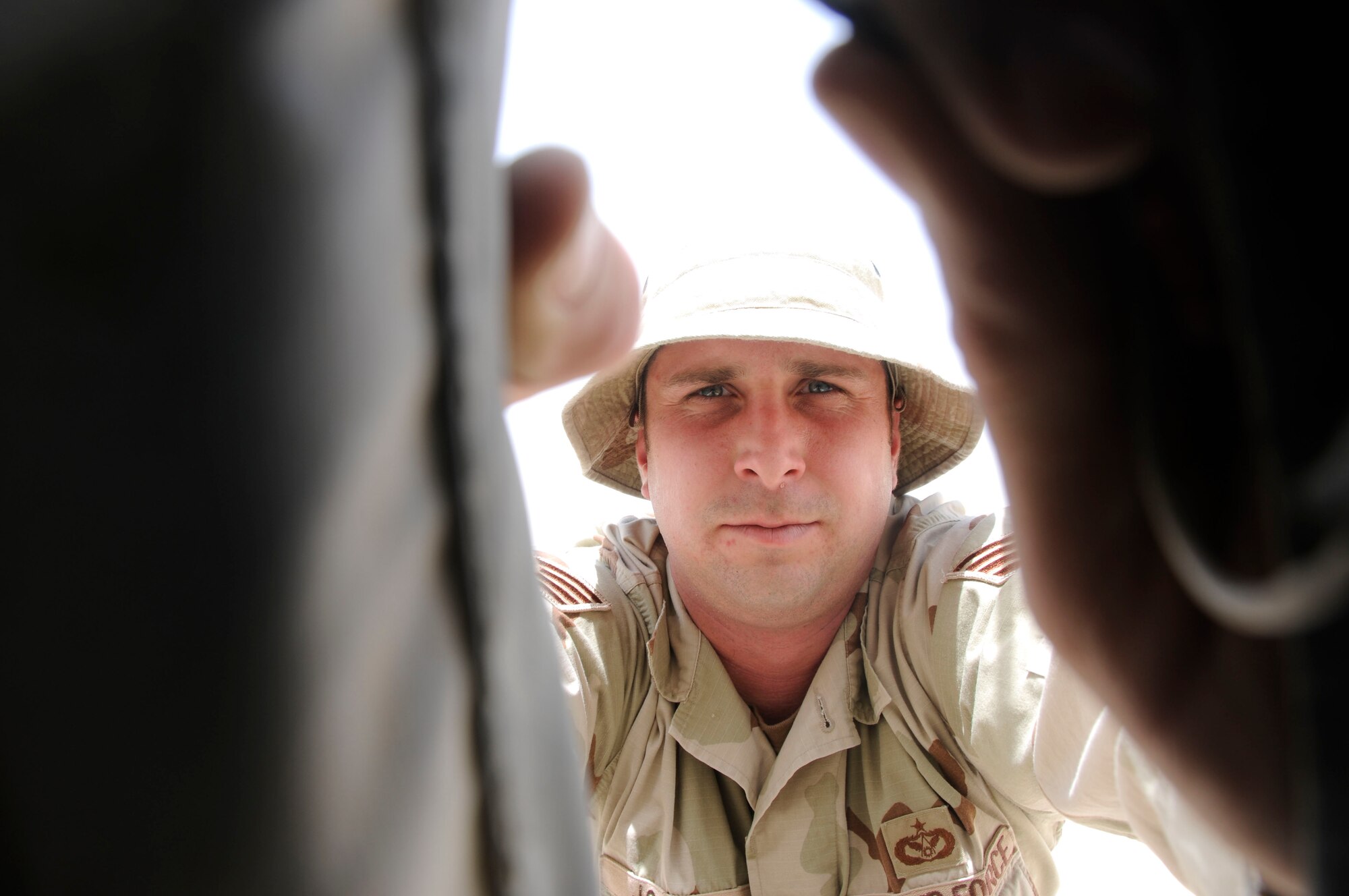 SOUTHWEST ASIA--Staff Sgt. Raymond Johnson, 379th Expeditionary Civil Engineer Squadron structures craftman from Pope Air Force Base, N.C., closes up the side of a tent. He led more than 30 Soldiers to erect 10 tents at the newly constructed Army PATRIOT Battery site. (U.S. Air Force photo/ Senior Airman Domonique Simmons.)