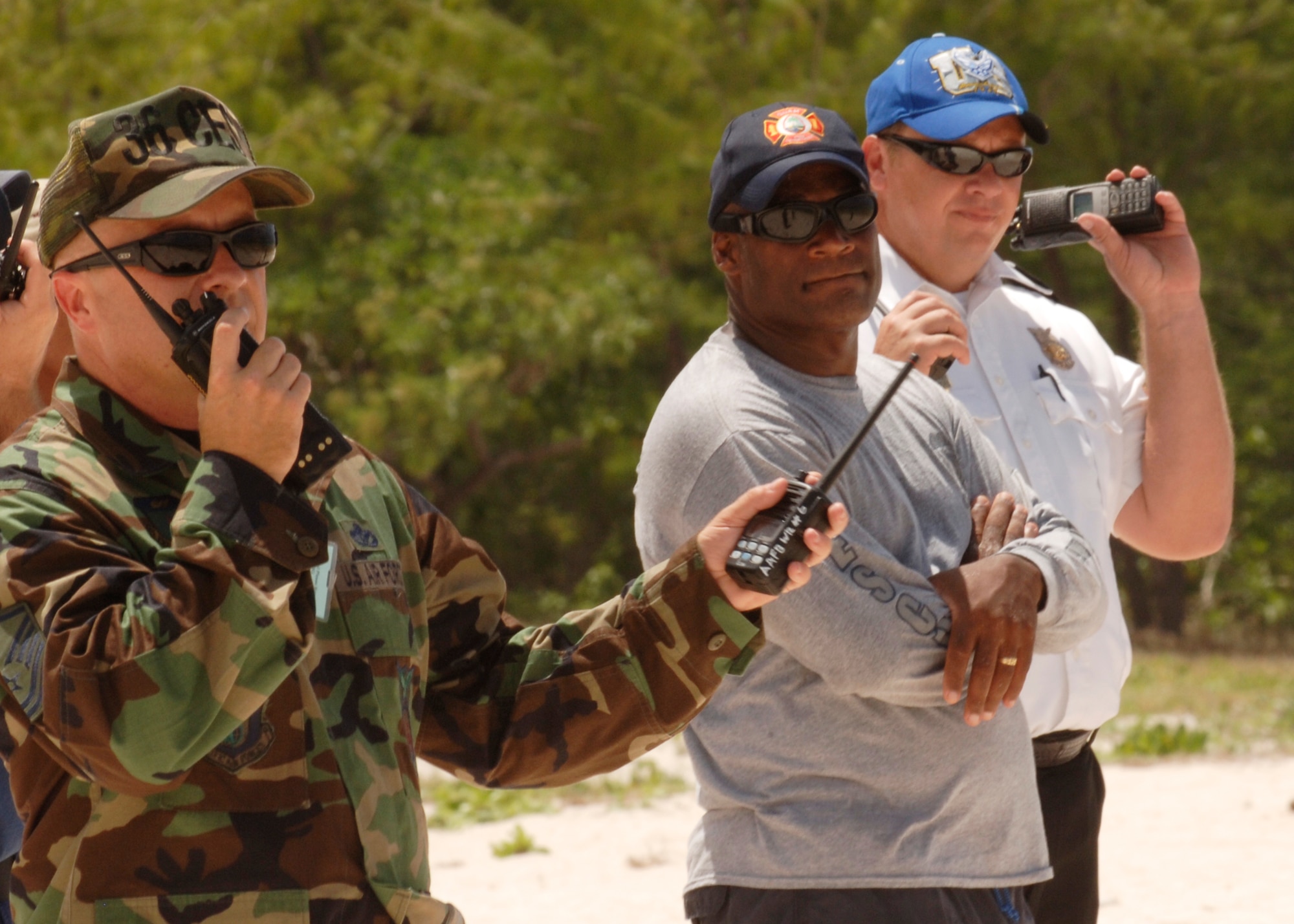 Master Sgt. Daniel Cline Exercise Evaluation Team (EET) Member pass along exercise inputs to Staff Sgt. Francis Tagalog, EET on neighboring Sirena Beach during the Search and Rescue Exercise at Tarague Beach. The exercise enhances the tactical inter-operability within the island of Guam for water rescue emergencies in realistic ocean environment. The SAREX also included members from Guam's police and fire departments, the Navy's Helicopter Sea Combat Squadron 25, Coast Guard, Jeff's Pirates Cove Rescue Team. (U.S. Air Force photo by Airman 1st Class Nichelle Griffiths)