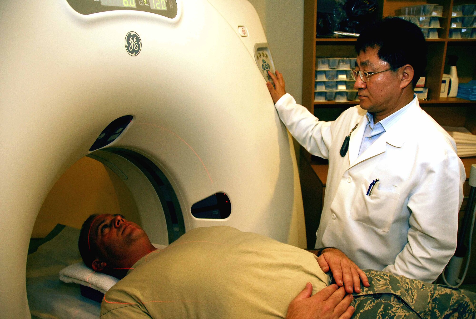 Mr. Yi Hwan Hyung, a computed tomography technologist, prepares to run a computed tomography of Staff Sgt. Ray Winstead, 51st Fighter Wing, at the base hospital Tuesday. The CT is used to generate a three-dimensional image of an object’s inside from a large series of two-dimensional X-ray images taken around a single axis of rotation. (U.S. Air Force photo/Senior Airman Christopher Boitz)