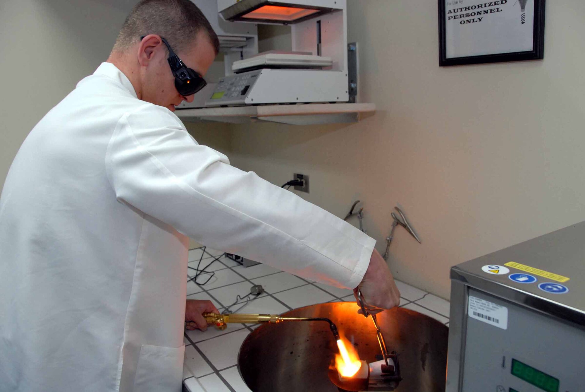 Senior Airman Dennis Bermel, 51st Dental Squadron lab technician, uses a blow torch to liquefy gold. The gold is then poured into a stone molding and will be used as a cast. This is the first stage of a two-day process to create a single cast which will be used on a dental patient. (U.S. Air Force photo/Staff Sgt. Lakisha Croley)