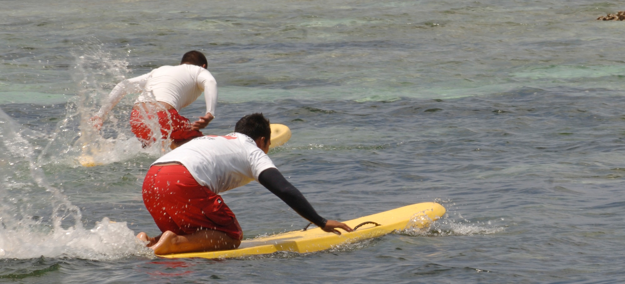 Andersen Air Force Base Lifeguards Ruben Cruz (left) and Christian Villanueva (right) swim out on rescue boards to perform a simulated water search and rescue during the SAREX May 8 at Tarague Beach. The exercise enhances the tactical inter-operability within the island of Guam for water rescue emergencies in realistic ocean environment. The SAREX also included members from Guam's police and fire departments, the Navy's Helicopter Sea Combat Squadron 25, Coast Guard, Jeff's Pirates Cove Rescue Team. (U.S. Air Force photo by Airman 1st Class Nichelle Griffiths)