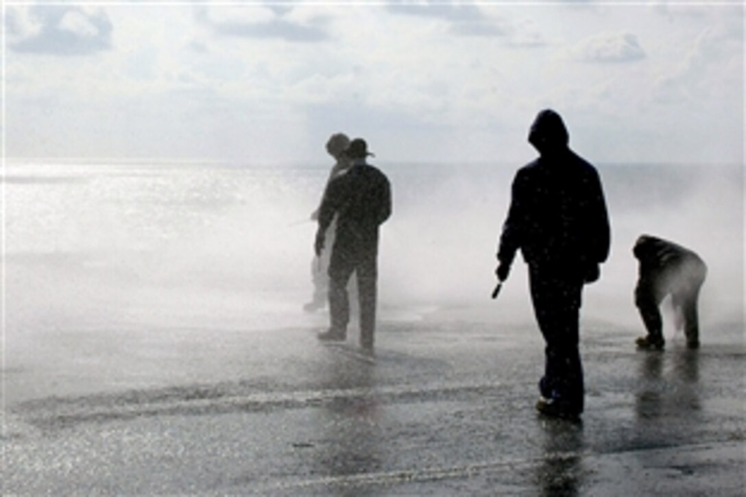 U.S. Navy seamen check nozzles on the flight deck aboard the amphibious assault ship USS Bataan as the ship tests her counter-measure wash-down system in the Atlantic Ocean, May 6, 2008.