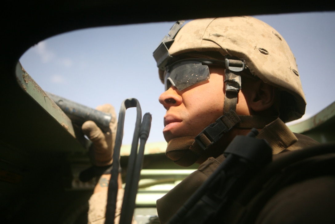 While engaged in a vehicle patrol along Route Mobile in western Al Anbar province, Iraq, Sgt. Justin O. Smallwood, 23, a scout squad leader from Great Falls, Va., with Team Mustang, 2nd Light Armored Reconnaissance Battalion, Regimental Combat Team 5, scans the roadway for any suspicious activity May 10. Team Mustang will maintain security of the highway with the Iraqi Highway Patrol to ensure insurgents don't harm the citizens of the area until the day they hand over all responsibility to the Iraqi Security Forces.
