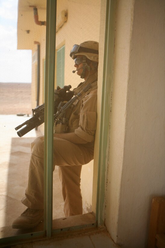 Lance Cpl. Brandon J. Frazer, 21, a scout from Kissame, Fla., with Team Mustang, 2nd Light Armored Reconnaissance Battalion, Regimental Combat Team 5, provides security during a meeting with Iraqi citizens while patrolling along Route Mobile of western Al Anbar province, Iraq, May 8. The Marines took time to visit citizens along Route Mobile to ensure insurgents weren't in the area to cause damage or harm the residents or Coalition forces.