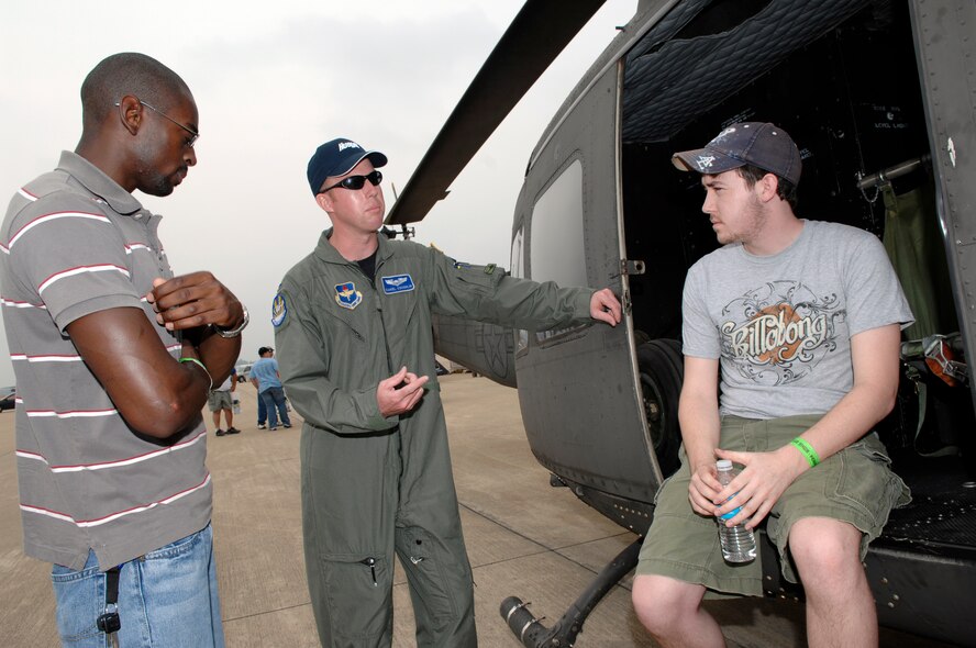 BARKSDALE AIR FORCE BASE, La. -- U.S. Air Force 1st Lieutenant Daniel Coughlin, 23rd Flight Training Squadron, discusses the capabilities of the UH-1 Huey helicopter with Marcus Thompkins (L) and Jason Barnes on the flight line of Barksdale Air Force Base, La. during the 2008 Defenders of Liberty Air Show.  The air show commemorates the 75th anniversary of Barksdale Air Force Base.  (U.S. Air Force photo by TSgt Laura K. Smith)