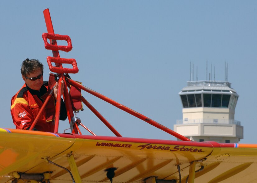 Gene Soucy attaches a harness aboard his aircraft in preparation  for a wing walker act done by his partner Teresa Stokes at Barksdale Air Force Base, Louisiana, on April 21, 2007. This event was part of the Defender's of Liberty Air Show 2007 held at Barksdale this weekend. (U.S. Air Force photo by Airman 1st Class Joanna M. Kresge)