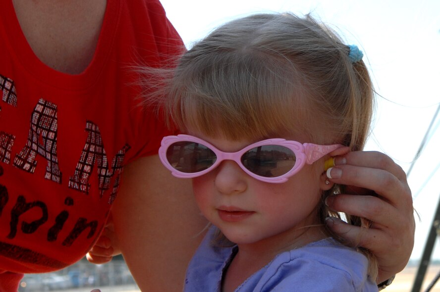BARKSDALE AIR FORCE BASE, La. - Vanessa Coreen helps her daughter, Legacy, put in her ear plugs during the Defenders of Liberty Air Show held here May 9. (U.S. Air Force photo by Airman 1st Class Joanna M. Kresge)