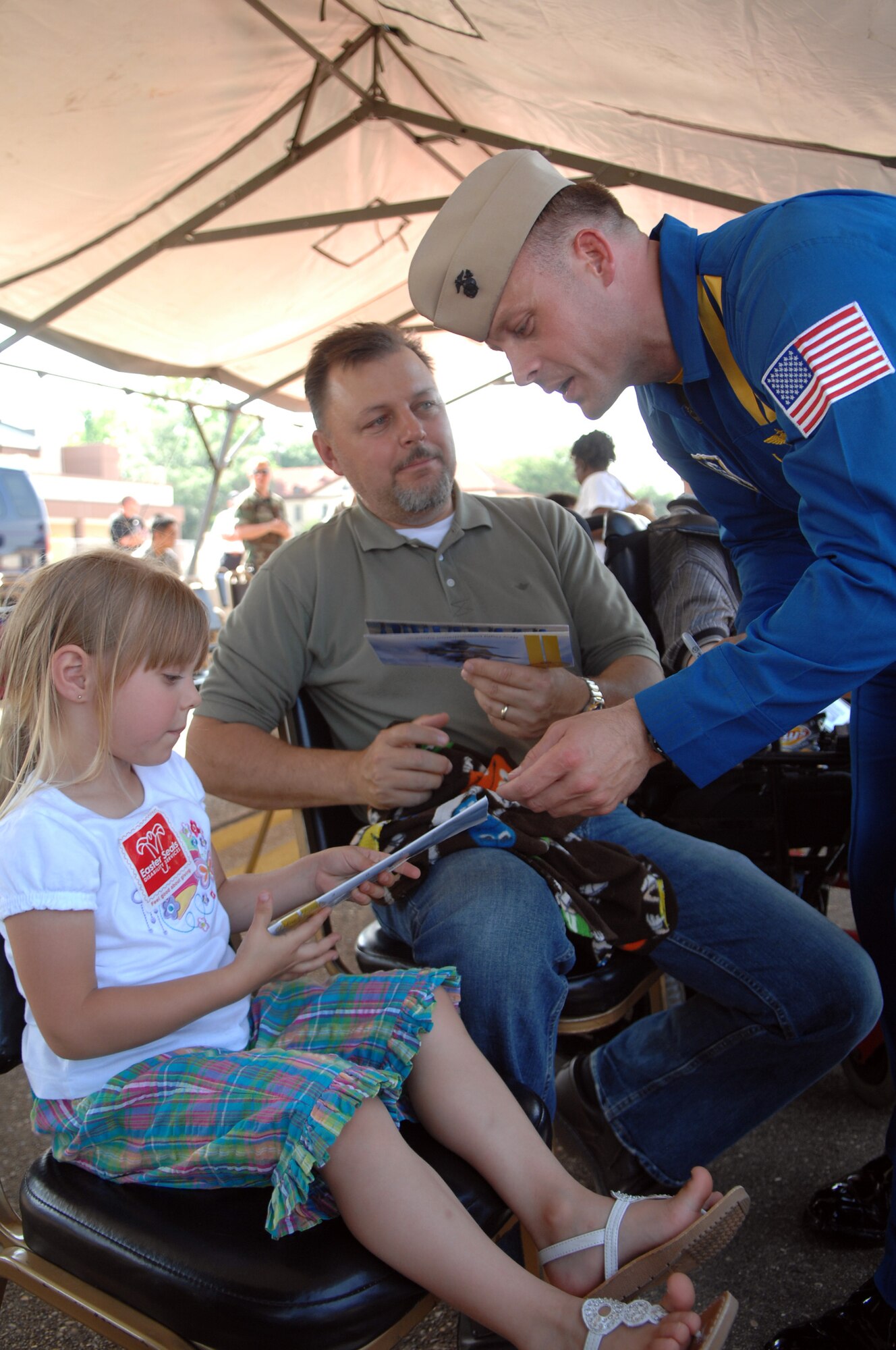 BARKSDALE AIR FORCE BASE, La. - A member of the U.S. Navy Blue Angels signs autographs for Ed Nagot and his daughter, Daly, during the Defenders of Liberty Air Show held here May 9. (U.S. Air Force photo by Airman 1st Class Joanna M. Kresge)