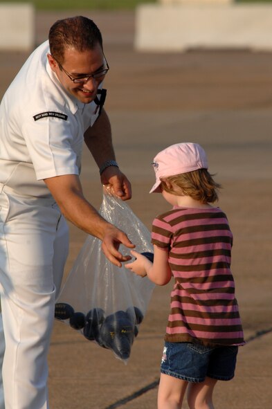 BARKSDALE AIR FORCE BASE, La. - Kirsten Wrightbert daughter of the 2d Security Forces Squadron's Senior Airman Aaron Larsen,  receives a mini-football from a member of the Navy Top 40 Band New Orleans on May 9. The Navy band performed during the twilight portion of the Defenders of Liberty Air Show. (U.S. Air Force photo by Airman 1st Class Joanna M. Kresge)