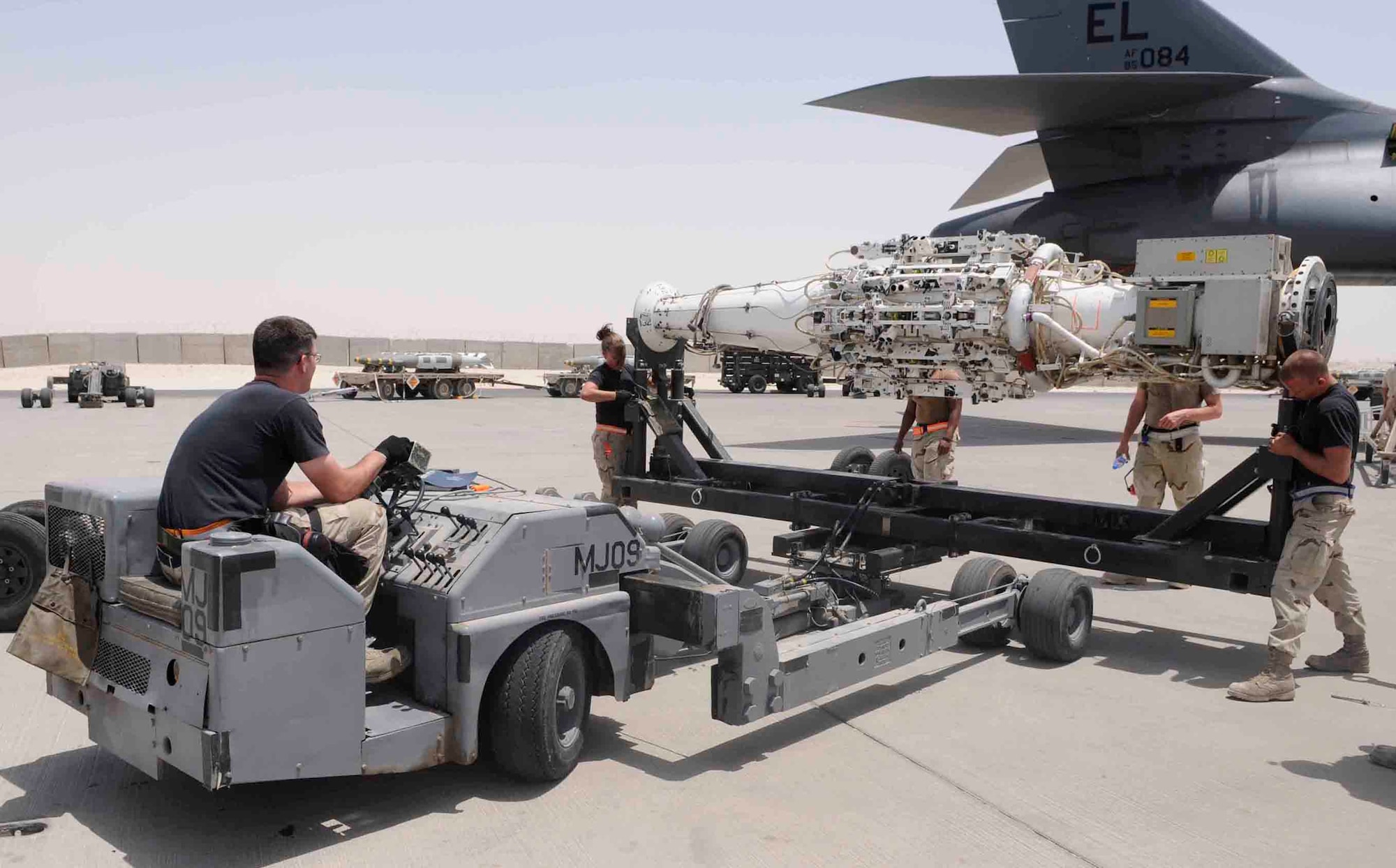 Staff Sgt. Jacob Sherwood operates a MJ-40 bomb lift truck while Airman 1st Class Emily Stettler and Airman 1st Class Thomas J. Howe secure a conventional rotary launcher before loading it onto a B1 aircraft. They are assigned with 379th Expeditionary Aircraft Maintenance Squadron and deployed from Ellsworth Air Force Base, S.D. (Tech. Sgt. Johnny Saldivar)
