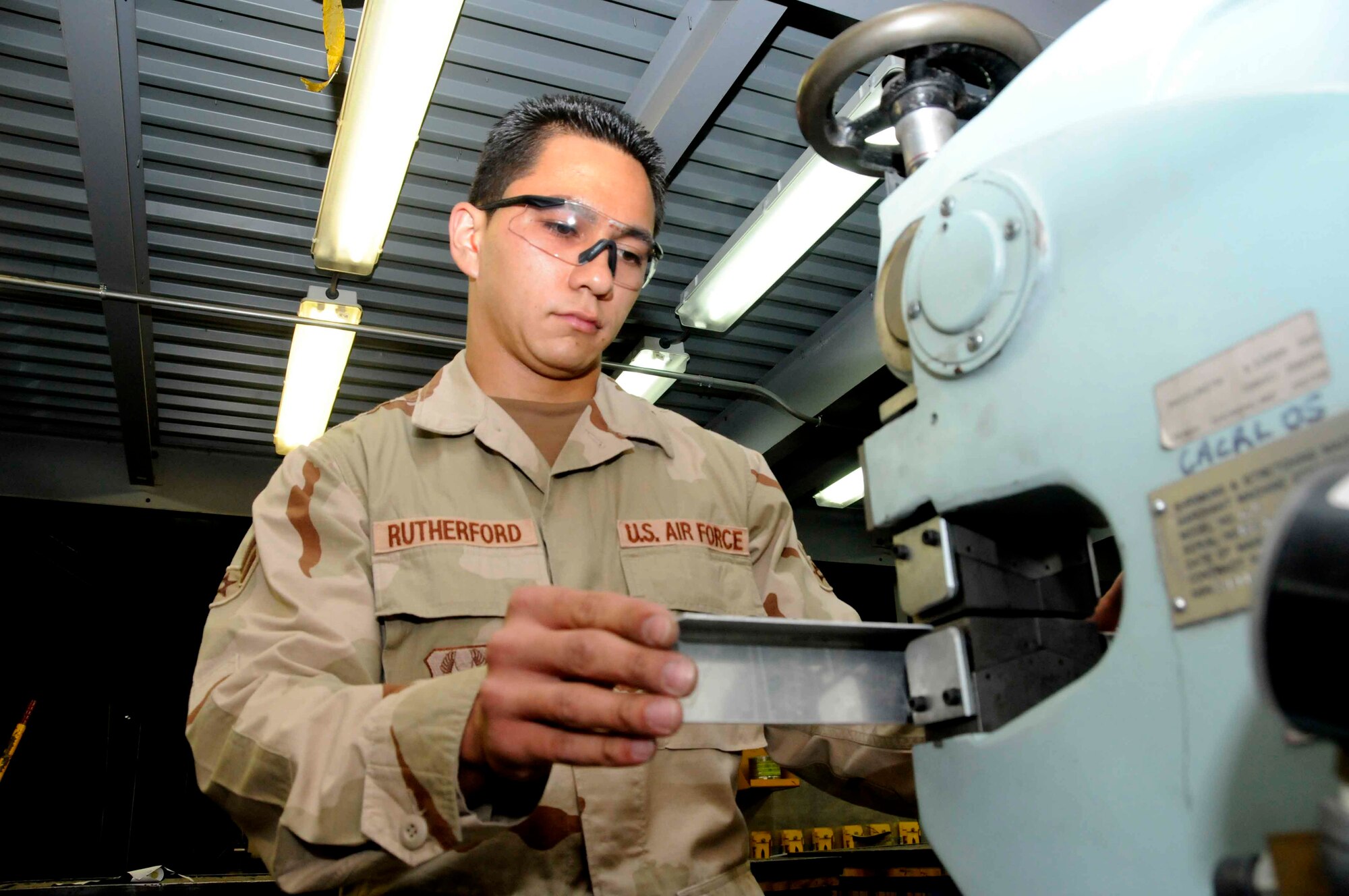 Airman 1st Class Michael Rutherford bends and shapes a piece of sheet metal. He volunteered for a 30-day deployment here as an Air Reserve Technician. (U.S. Air Force photo/Senior Airman Domonique Simmons)