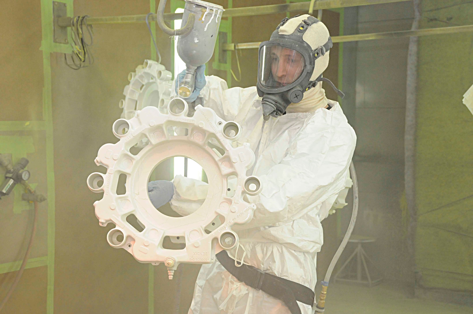 Senior Airman Geoffrey Sorensen paints a KC-135 aircraft brake part May 3. Painting the part helps protect it from corrosion in the extreme desert climate.(U.S. Air Force photo/Senior Airman Domonique Simmons)