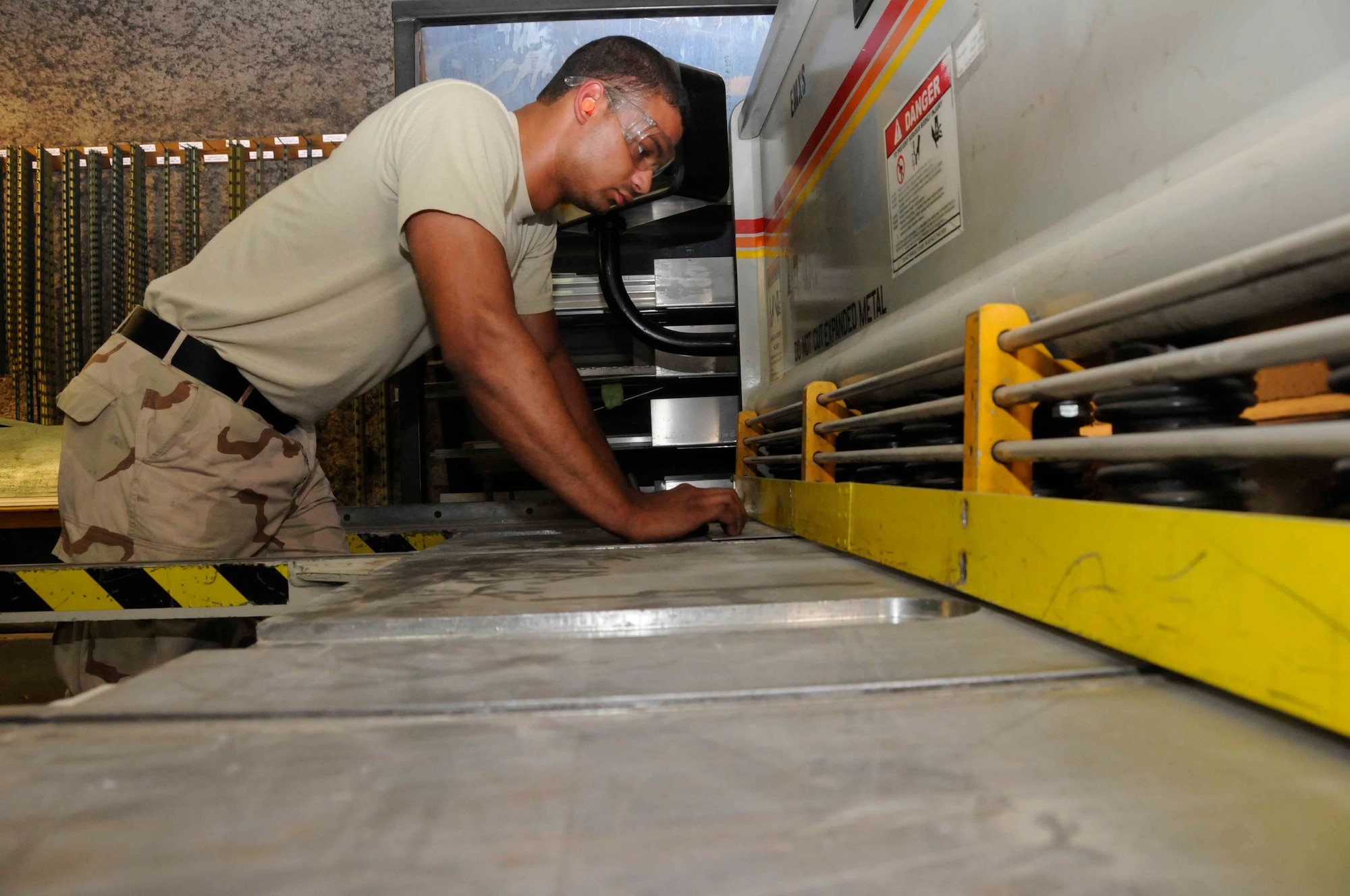 Senior Airman Brooks Johnson, 379th Expeditionary Maintenance Squadron, cuts a piece of titanium metal to a desired size using a metal cutting machine May 3. Airman Johnson uses a series of different machines to make accurate molds or replacement parts for different types of aircraft. (U.S. Air Force photo/Senior Airman Domonique Simmons)