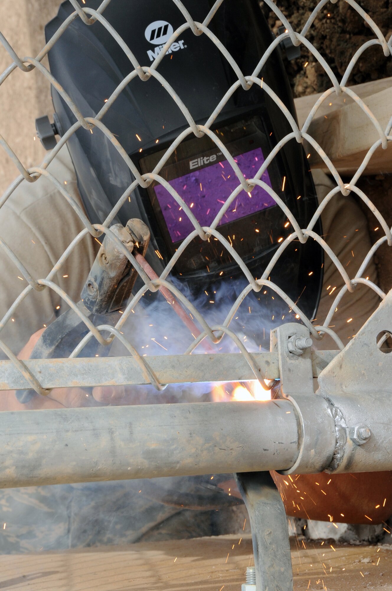 ALI BASE, Iraq -- Airman 1st Class Aaron Nickell, 407th Expeditionary Civil Engineering Squadron structures specialist, welds a fence together here May 10.  The structures team installed gates to enhance security at the Containerized Airport Surveillance Radar.  Airman Nickell is deployed from Eielson AFB, Alaska.  (U. S. Air Force photo / Tech. Sgt. Sabrina Johnson)