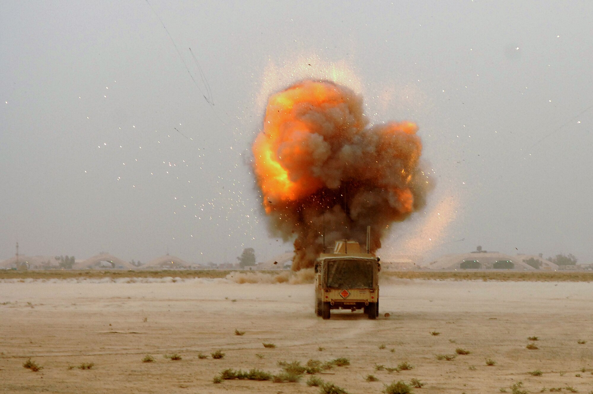 BALAD AIR BASE, Iraq -- A fire ball explodes from a crater during a controlled detonation of various munitions shooting fragments of molten metal in all directions 500 feet in front of a Joint Explosive Ordnance Disposal Rapid Response Vehicle here, May 9. Controlled detonations are executed by members of the 332nd Expeditionary Civil Engineer Squadron explosive ordnance disposal team and are a means of disposing of unexploded ordnances to ensure they cannot be used by enemy forces. (U.S. Air Force photo/ Senior Airman Julianne Showalter)