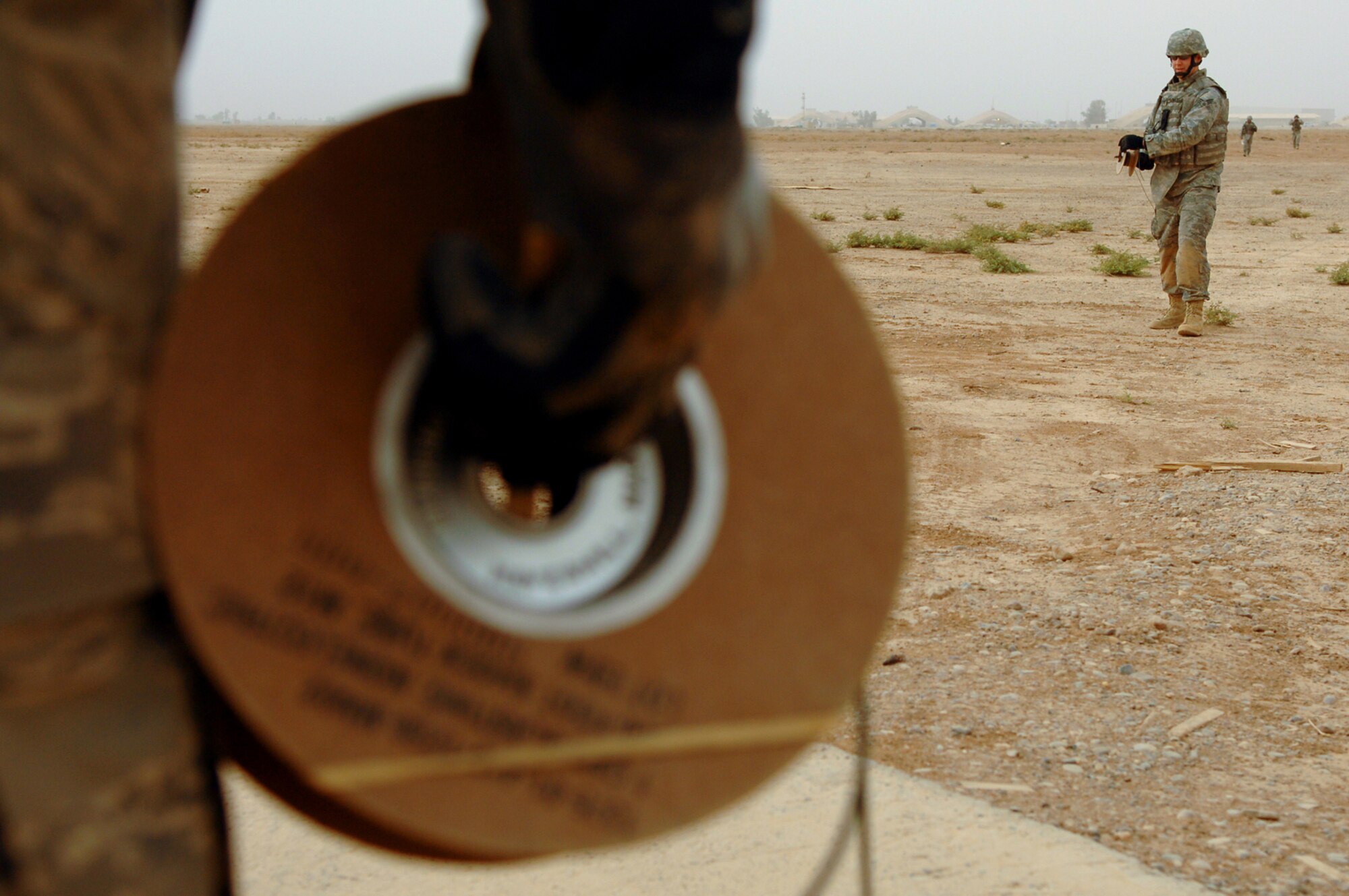 BALAD AIR BASE, Iraq -- Senior Airman James Rowlett, 332nd Expeditionary Civil Engineer Squadron explosive ordnance disposal, rolls out shock tubing before a controlled detonation of various munitions here, May 9. The tubing sends a charge to the blasting cap that is placed onto C-4 which then detonates. Airman Rowlett is deployed from Westover Air Reserve Base, Mass. (U.S. Air Force photo/ Senior Airman Julianne Showalter)