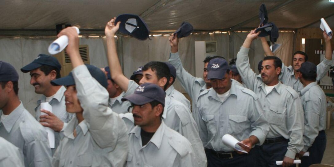 A class of newly graduated Iraqi Policemen celebrate their accomplishment at Al Anbar Ramadi District Training Headquarters May 8. Although the city has close to the number of policemen considered necessary, the school's leaders will continue training recruits and placing policemen on the streets to further restrain the insurgent's activities. "The more Iraqi Police the city has, the better the security situation will be because their presence is also serves as a deterrent for the insurgency," said Gerard C. Dempster, Headquarters and Service Commander and direct liaison for the Iraqi Security Forces, 1st Battalion, 9th Marine Regiment, Regimental Combat Team 1.
