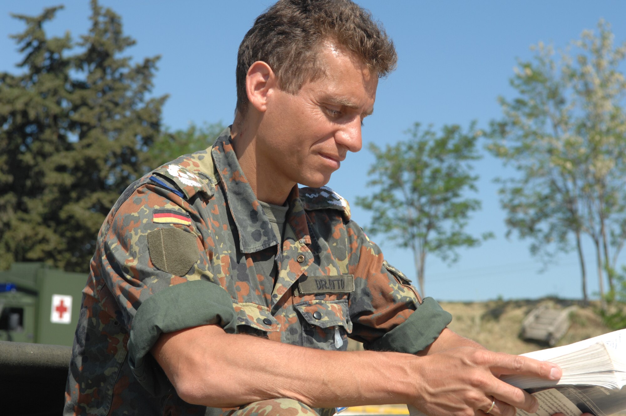 DIVULJE TRAINING BASE, Croatia – German Army Lt. Col. (Dr.) Christoph Otto flips through a medical manual while awaiting more moulage patients after a simulated earthquake May 10 during the 2008 Medical Training Exercise in Central and Eastern Europe (MEDCEUR).  The simulated earthquake is part of a mass-casualty exercise to apply the knowledge troops gained during MEDCEUR training.  Fifteen nations are participating in the exercise from May 2 through 14. The exercise focuses on mass-casualty training scenarios and humanitarian aid in response to crises situations. MEDCEUR is a Joint Chiefs of Staff regional/multilateral exercise sponsored by U.S. European Command. Croatia is hosting the 2008 exercise which has drawn about 400 multi-nationals in support of the Partnership for Peace initiative. (U.S. Air Force photo/Staff Sgt. Kristin Ruleau) 