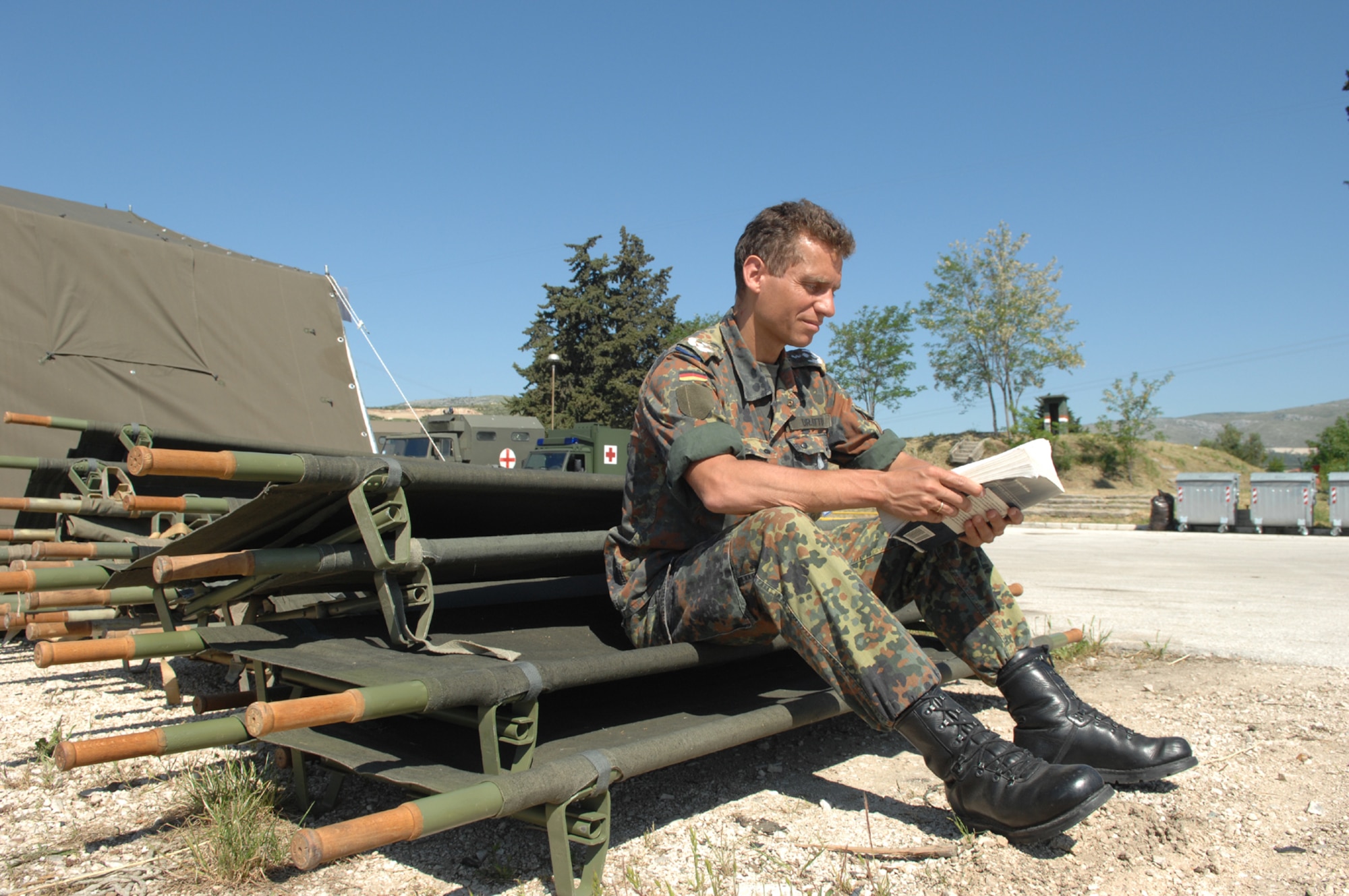 DIVULJE TRAINING BASE, Croatia – German Army Lt. Col. (Dr.) Christoph Otto flips through a medical manual while awaiting more moulage patients after a simulated earthquake May 10 during the 2008 Medical Training Exercise in Central and Eastern Europe (MEDCEUR).  The simulated earthquake is part of a mass-casualty exercise to apply the knowledge troops gained during MEDCEUR training.  Fifteen nations are participating in the exercise from May 2 through 14. The exercise focuses on mass-casualty training scenarios and humanitarian aid in response to crises situations. MEDCEUR is a Joint Chiefs of Staff regional/multilateral exercise sponsored by U.S. European Command. Croatia is hosting the 2008 exercise which has drawn about 400 multi-nationals in support of the Partnership for Peace initiative. (U.S. Air Force photo/Staff Sgt. Kristin Ruleau) 
