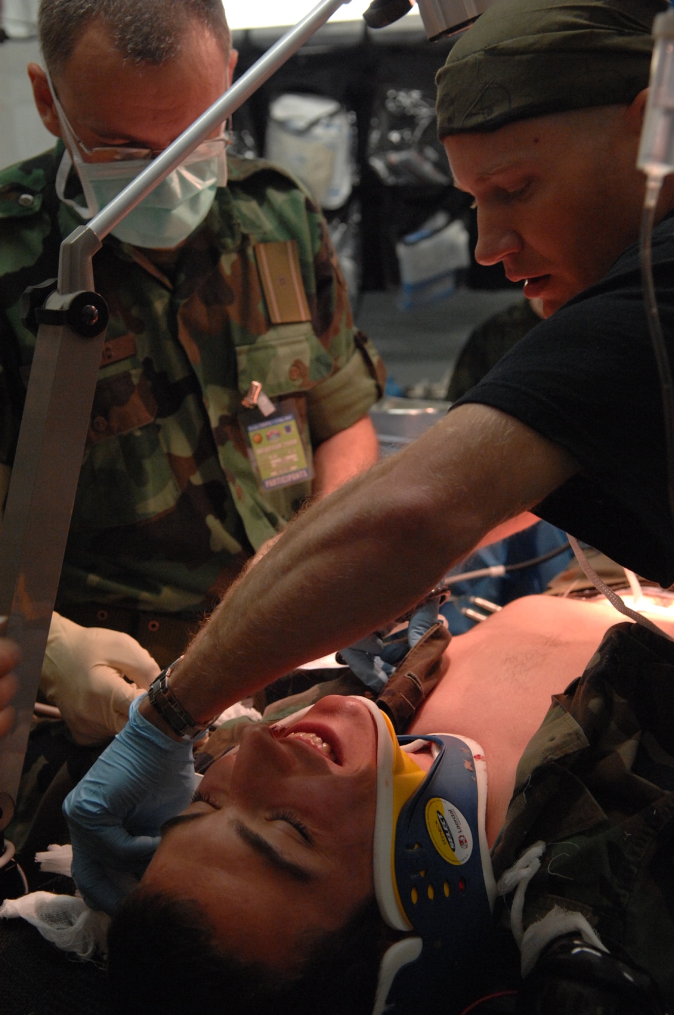 DIVULJE TRAINING BASE, Croatia – Serbian Army Maj. (Dr.) Sasa Dragovic (left) and U.S. Air Force Maj. (Dr.) Michael Petro prepare to simulate an operation on moulage patient Croatian Army Cadet Frano Grljusic after a simulated earthquake May 10 during the 2008 Medical Training Exercise in Central and Eastern Europe (MEDCEUR).  The simulated earthquake is part of a mass-casualty exercise to apply the knowledge troops gained during MEDCEUR training.  Fifteen nations are participating in the exercise from May 2 through 14. The exercise focuses on mass-casualty training scenarios and humanitarian aid in response to crises situations. MEDCEUR is a Joint Chiefs of Staff regional/multilateral exercise sponsored by U.S. European Command. Croatia is hosting the 2008 exercise which has drawn about 400 multi-nationals in support of the Partnership for Peace initiative. (U.S. Air Force photo/Staff Sgt. Kristin Ruleau) 