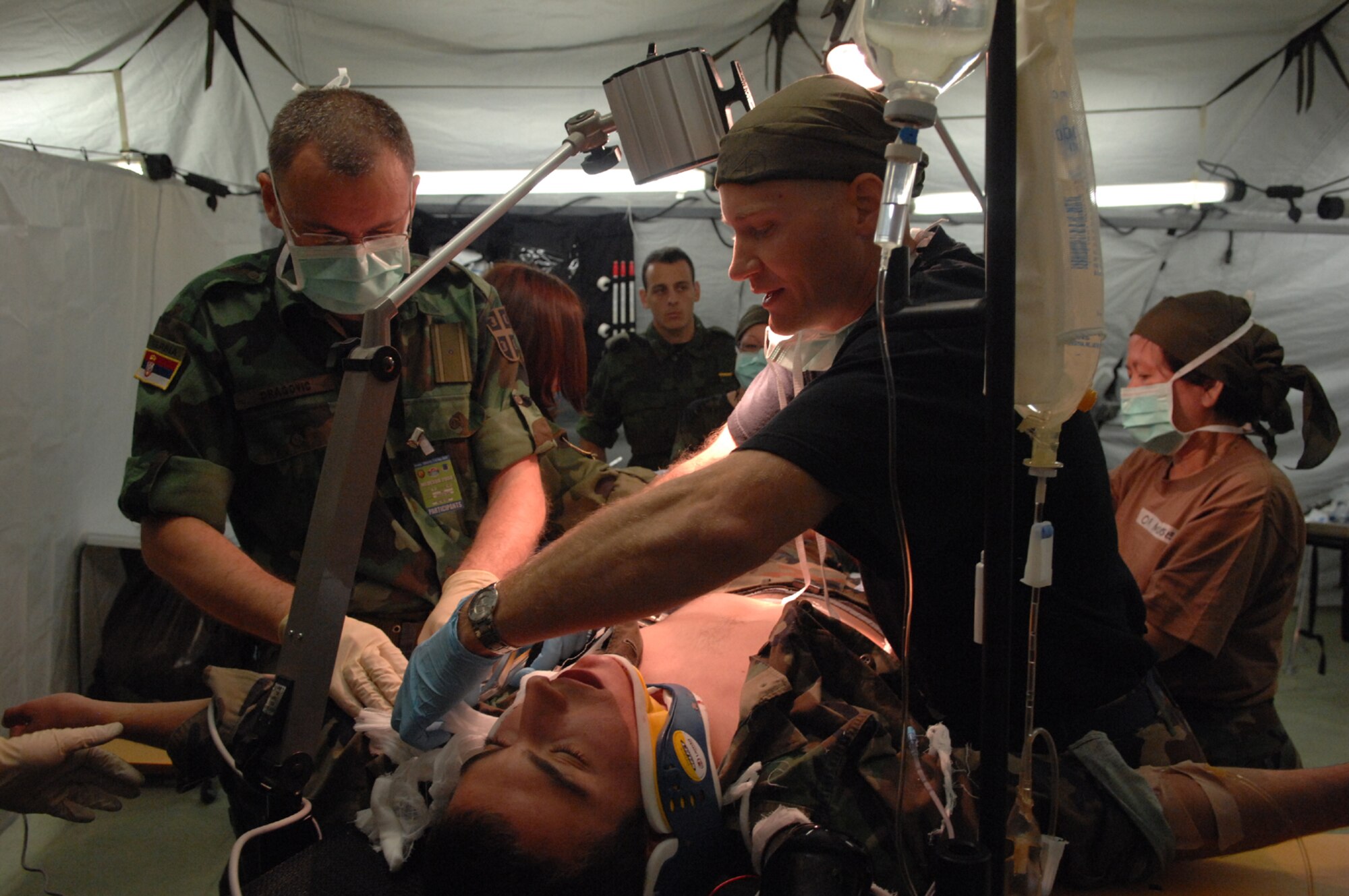 DIVULJE TRAINING BASE, Croatia – Serbian Army Maj. (Dr.) Sasa Dragovic (left) and U.S. Air Force Maj. (Dr.) Michael Petro prepare to simulate an operation on moulage patient Croatian Army Cadet Frano Grljusic after a simulated earthquake May 10 during the 2008 Medical Training Exercise in Central and Eastern Europe (MEDCEUR).  The simulated earthquake is part of a mass-casualty exercise to apply the knowledge troops gained during MEDCEUR training.  Fifteen nations are participating in the exercise from May 2 through 14. The exercise focuses on mass-casualty training scenarios and humanitarian aid in response to crises situations. MEDCEUR is a Joint Chiefs of Staff regional/multilateral exercise sponsored by U.S. European Command. Croatia is hosting the 2008 exercise which has drawn about 400 multi-nationals in support of the Partnership for Peace initiative. (U.S. Air Force photo/Staff Sgt. Kristin Ruleau) 