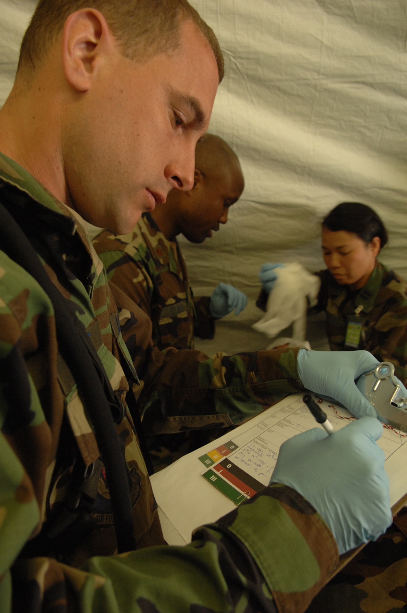DIVULJE TRAINING BASE, Croatia – U.S. Air Force Staff Sgt. Brian Schmit, a medical service craftsman with the 458th Expeditionary Medical Squadron, writes down the status of incoming moulage patients after a simulated earthquake May 10 during the 2008 Medical Training Exercise in Central and Eastern Europe (MEDCEUR).  The simulated earthquake is part of a mass-casualty exercise to apply the knowledge troops gained during MEDCEUR training.  Fifteen nations are participating in the exercise from May 2 through 14. The exercise focuses on mass-casualty training scenarios and humanitarian aid in response to crises situations. MEDCEUR is a Joint Chiefs of Staff regional/multilateral exercise sponsored by U.S. European Command. Croatia is hosting the 2008 exercise which has drawn about 400 multi-nationals in support of the Partnership for Peace initiative. (U.S. Air Force photo/Staff Sgt. Kristin Ruleau) 