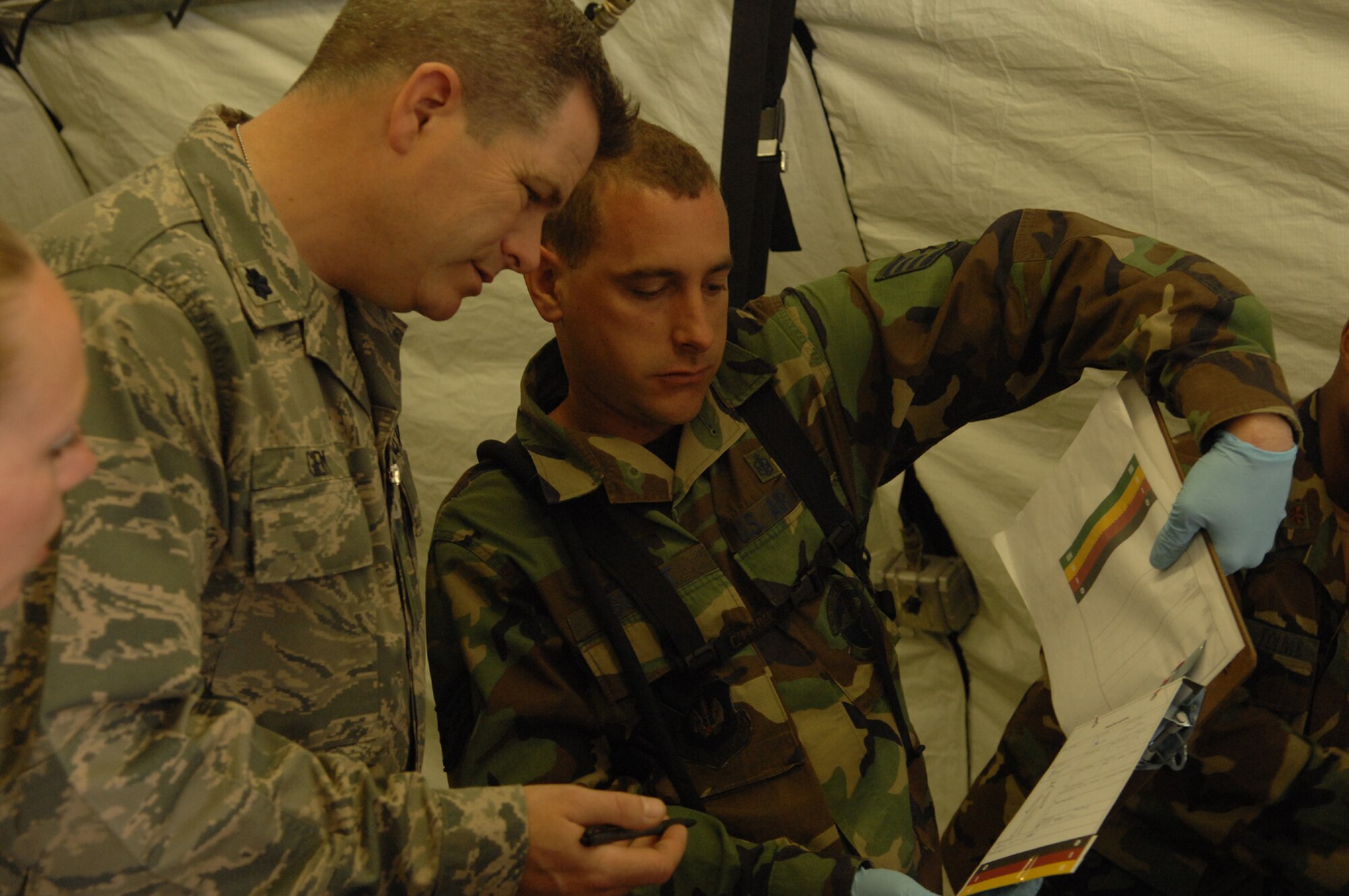 DIVULJE TRAINING BASE, Croatia – U.S. Air Force Staff Sgt. Brian Schmit, a medical service craftsman with the 458th Expeditionary Medical Squadron (EMS), consults Lt. Col. Sean Giery, a clinical nurse also with the 458th EMS, about the status of a moulage patient after a simulated earthquake May 10 during the 2008 Medical Training Exercise in Central and Eastern Europe (MEDCEUR).  The simulated earthquake is part of a mass-casualty exercise to apply the knowledge troops gained during MEDCEUR training.  Fifteen nations are participating in the exercise from May 2 through 14. The exercise focuses on mass-casualty training scenarios and humanitarian aid in response to crises situations. MEDCEUR is a Joint Chiefs of Staff regional/multilateral exercise sponsored by U.S. European Command. Croatia is hosting the 2008 exercise which has drawn about 400 multi-nationals in support of the Partnership for Peace initiative. (U.S. Air Force photo/Staff Sgt. Kristin Ruleau) 