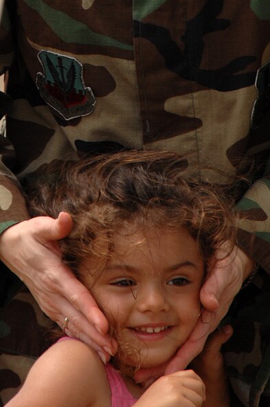 BARKSDALE AIR FORCEC BASE, La. -- Capt Allison Agliata covers the ears of her daughter Lia as an air craft flies over during the Defenders of Liberty Air Show held here May 10. This marks the 75th Anniversary of the base. (U.S. Air Force photo by Airman 1st Class Joanna M. Kresge)