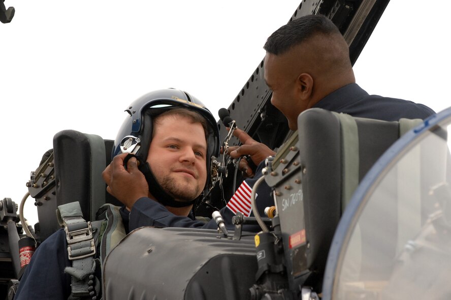 BARKSDALE AIR FORCE BASE, La. -- David McCart from Gap Broadcasting receives help donning his helmet from Staff Sgt. Deo Harrypersaud, a Navy Blue Angels crew chief before his media flight May 7. David is known as the radio personality 'Stiffler' on Shreveport's K94.5 radio station. (U.S. Air Force photo by Airman 1st Class Joanna M. Kresge)