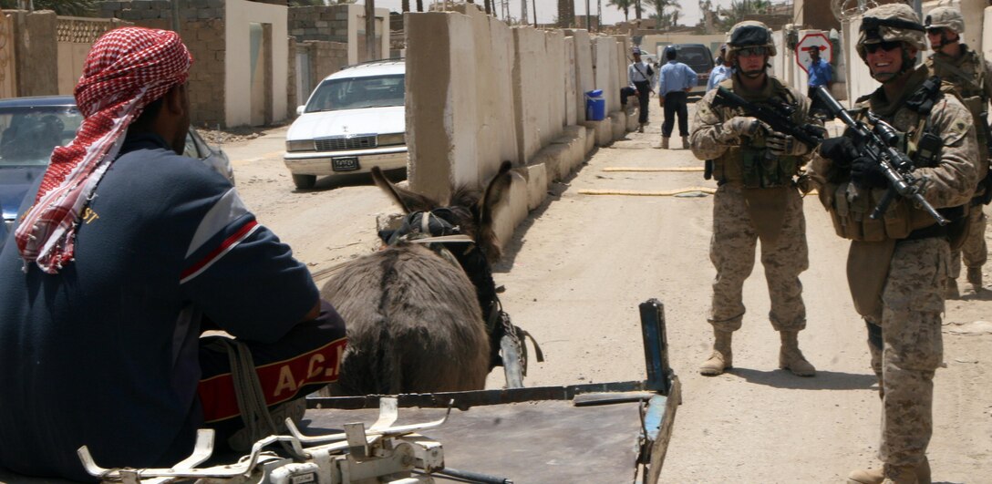 RAMADI, Iraq – (front right) Sgt. Michael S. Lauderback, a team leader with Mobile Assault Platoon 5, 1st Battalion, 9th Marine Regiment, Regimental Combat Team 1, interacts with a local during a foot patrol through Ramadi May 11. (Official U.S. Marine Corps photo by Lance Cpl. Casey Jones) (RELEASED)
