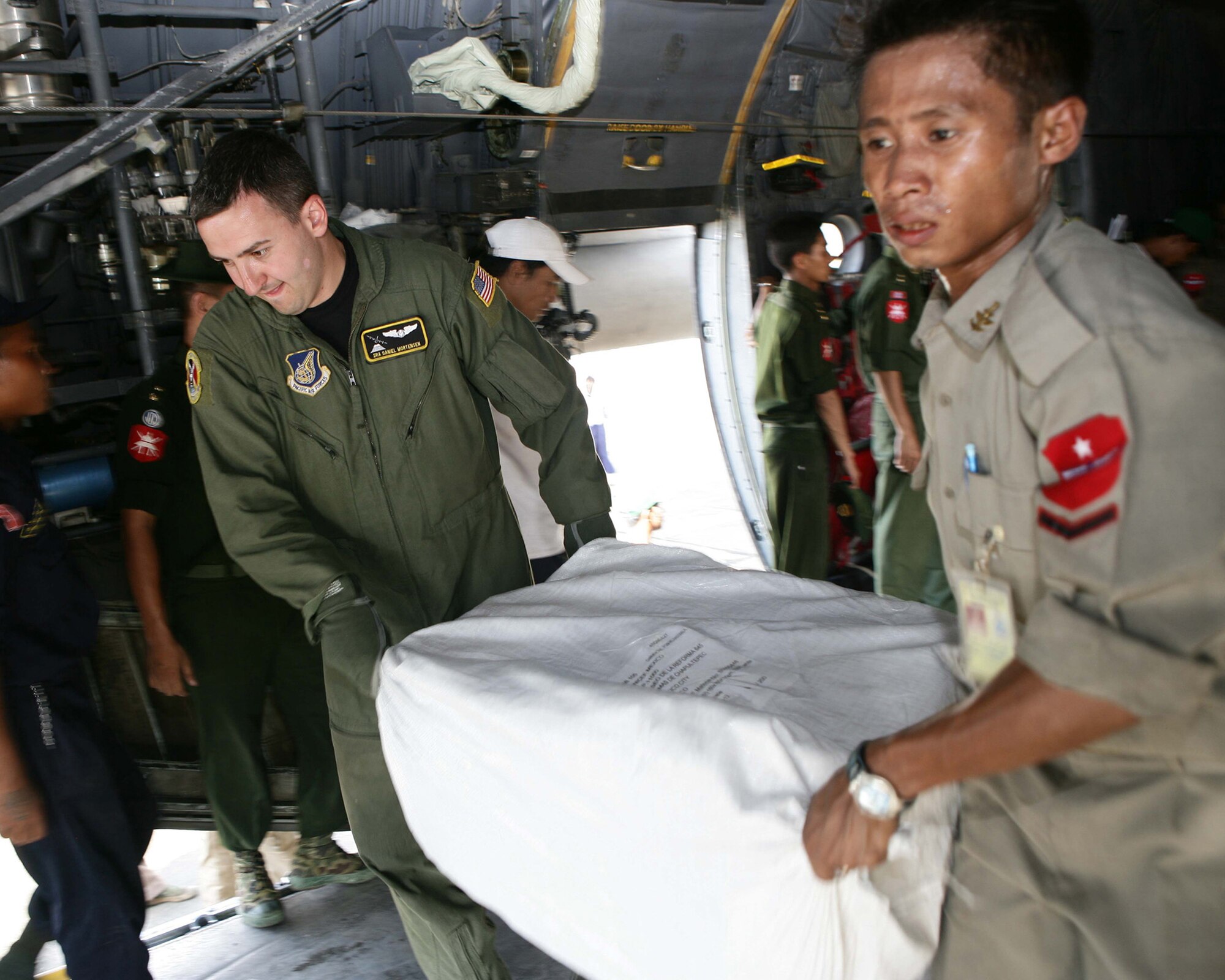 Service members from Burma and  United States work together to unload relief supplies from a U.S. Air Force C-130 at the Rangoon International Airport, Burma, on May 12, 2008. The shipment of water, mosquito nets and blankets is the first U.S. military flight in support of relief efforts to Burma following Tropical Cyclone Nagris that recently swept through the country May 2.  (U.S. Marine Corps photo by Sgt. Andres Alcaraz) 